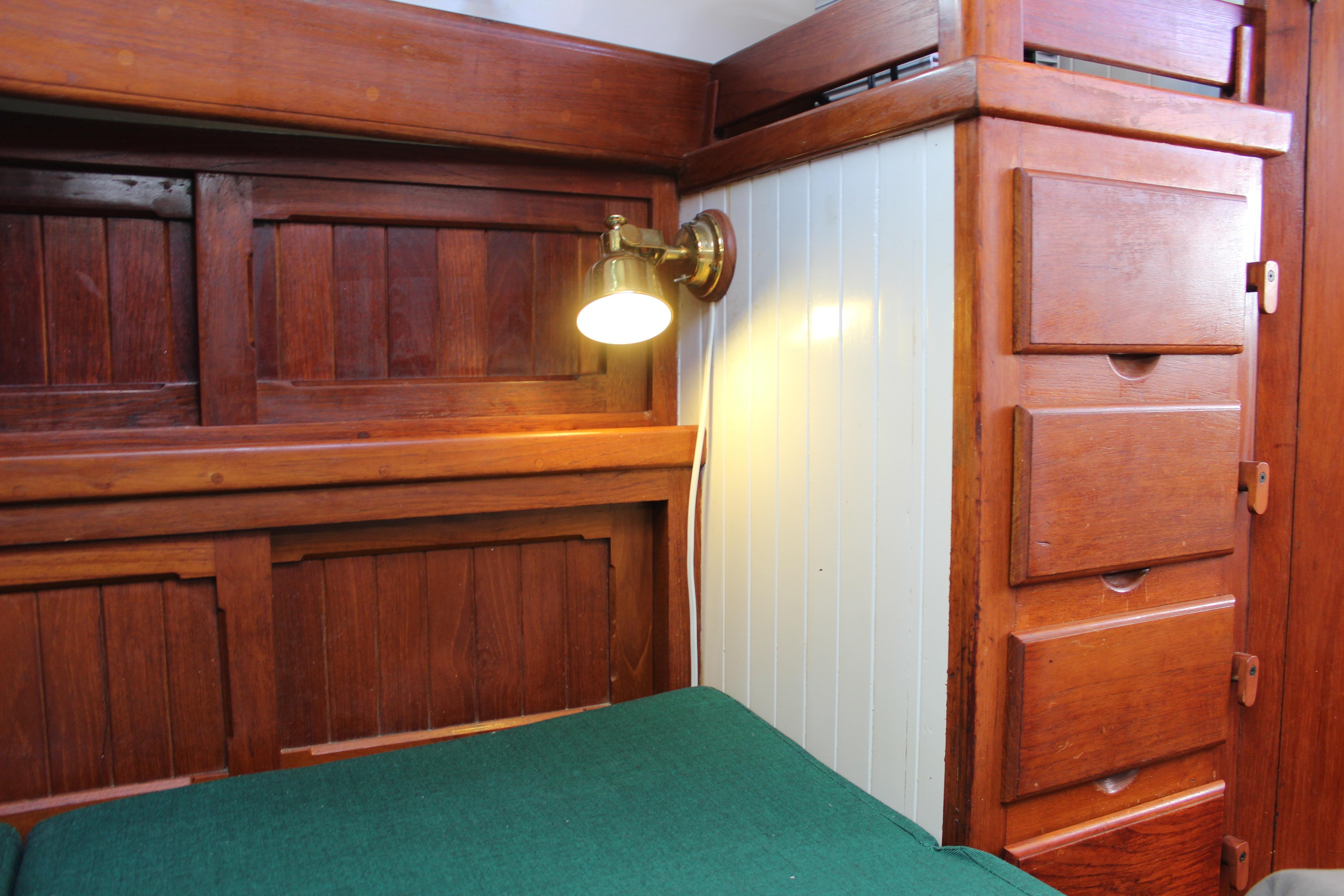 Cozy wooden cabin interior with a reading lamp, Kelly Peterson 46, 1981 model.