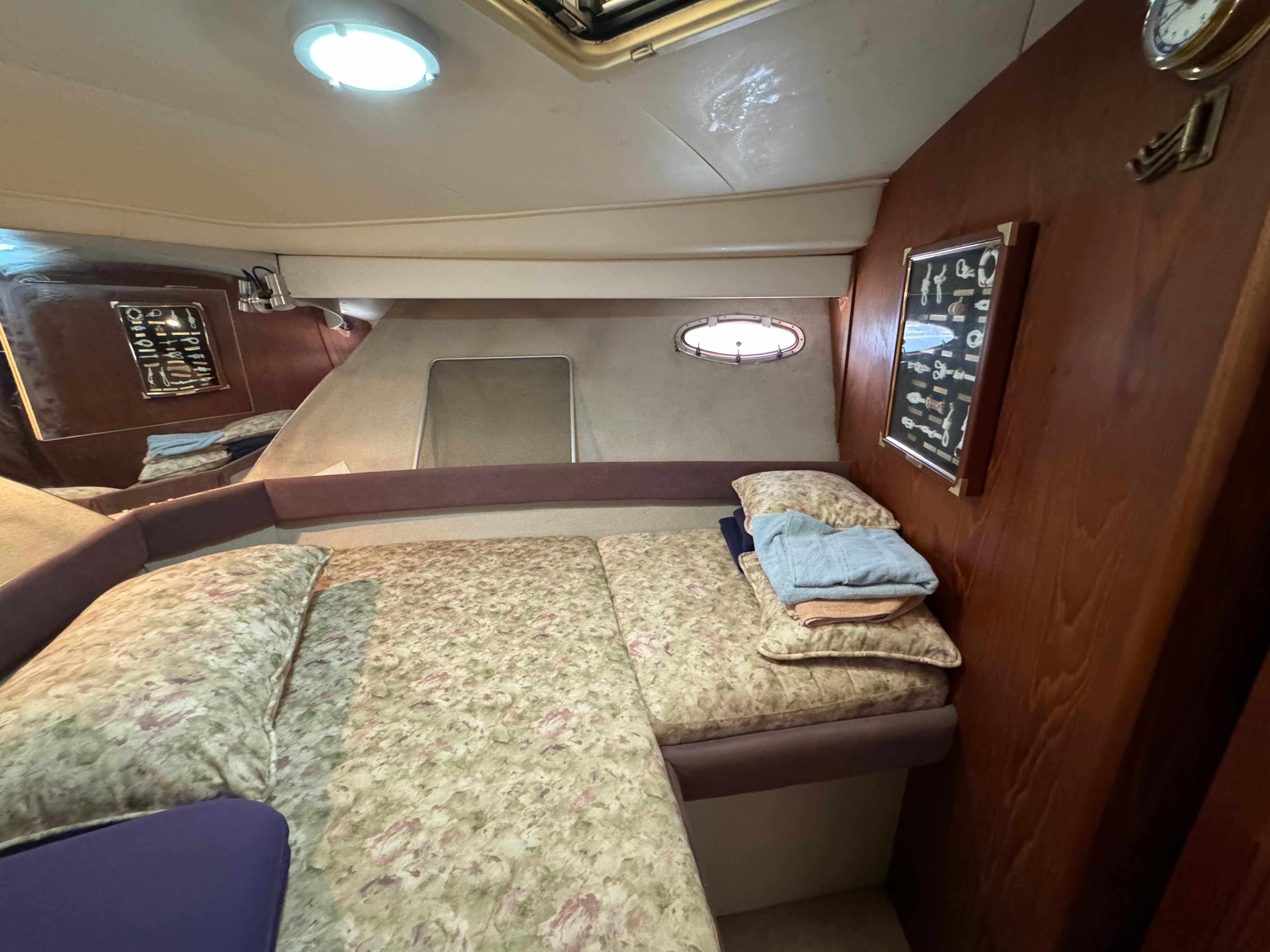 1991 Carver 33 Aft Cabin interior with cozy bed, wood paneling, and porthole window.
