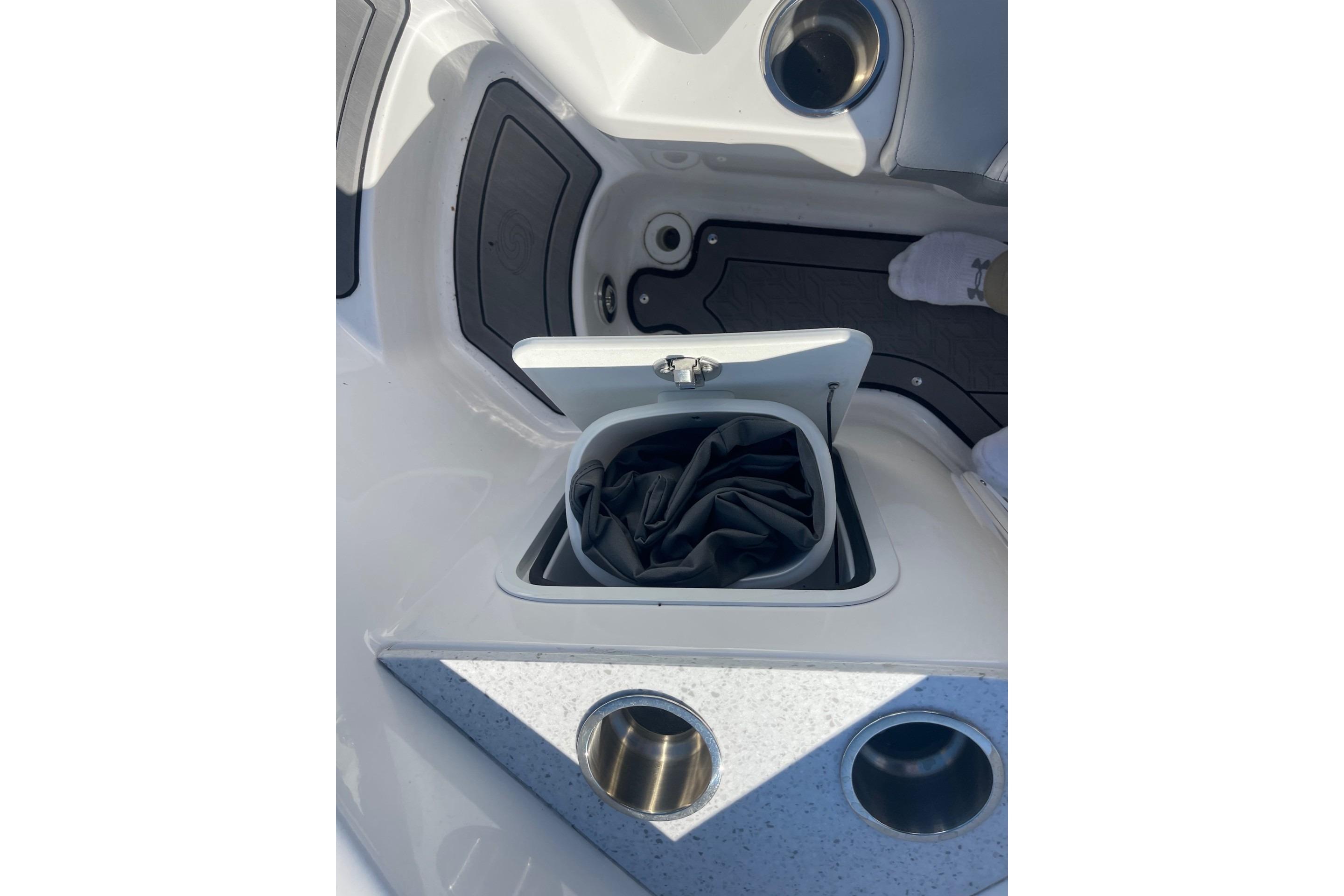 2023 Hurricane SunDeck 2400 OB boat storage compartment with cup holders.