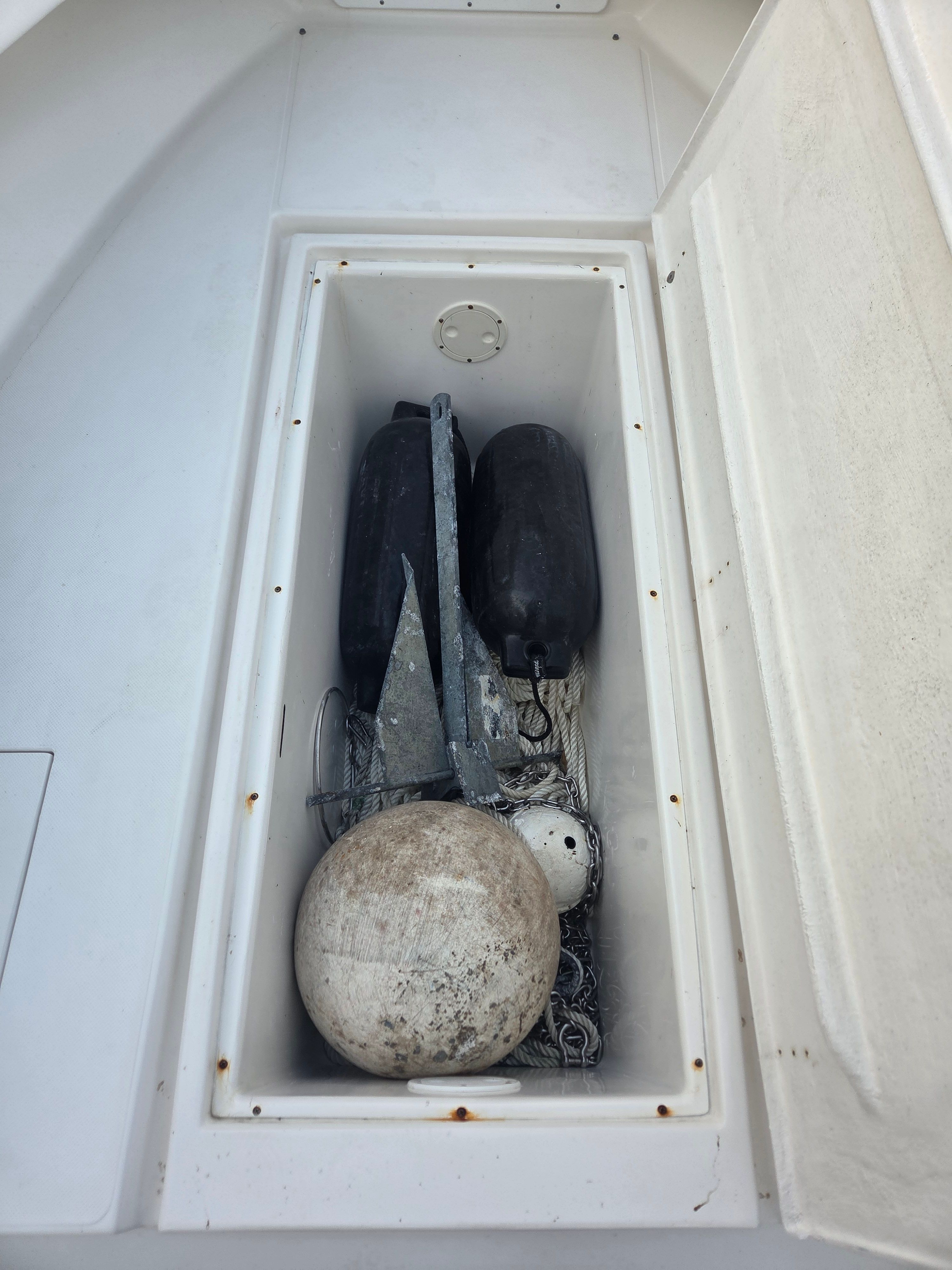 Boat anchor and fenders in storage compartment of Ocean Runner 29.