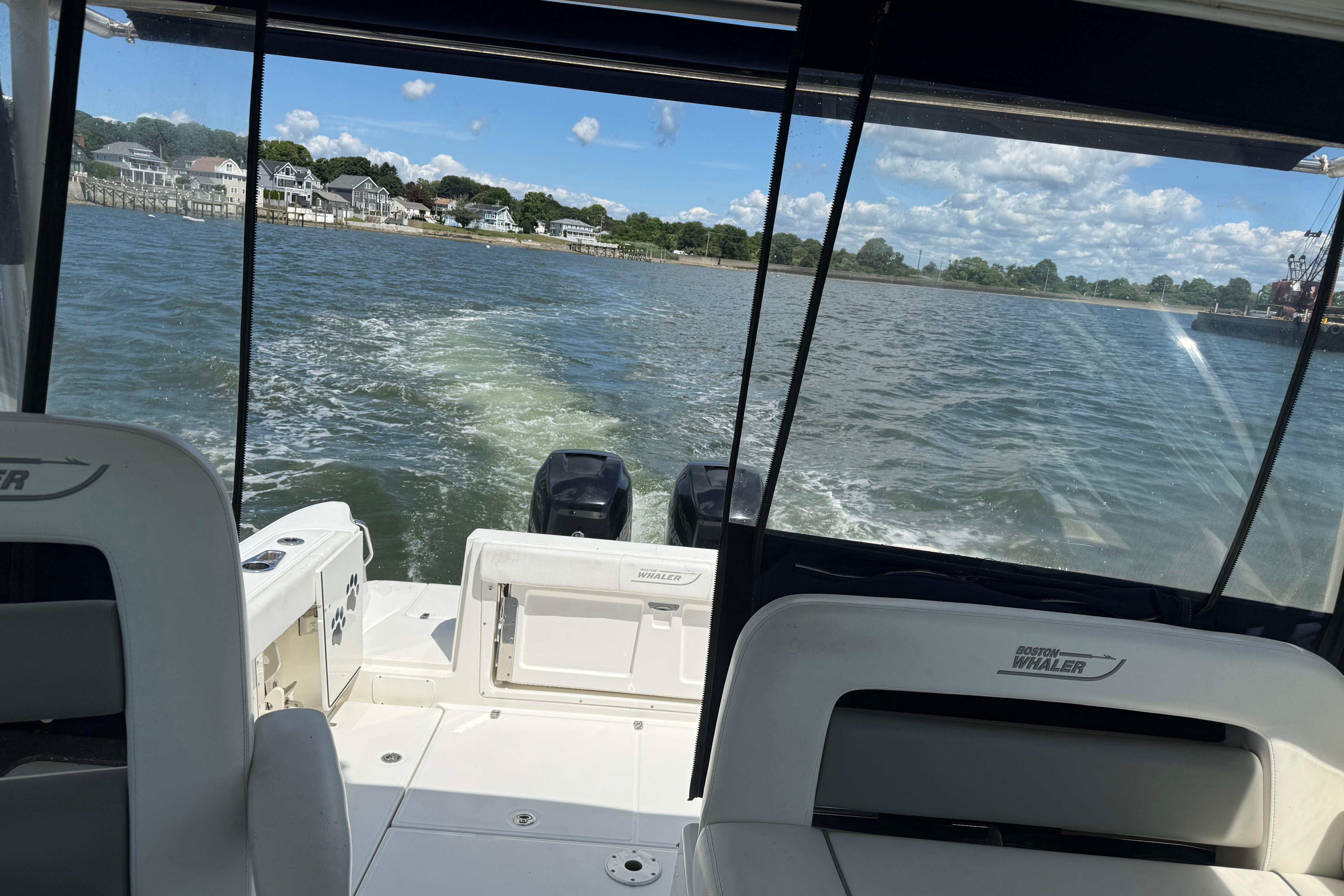 2013 Boston Whaler 315 Conquest cruising on a scenic waterway with clear skies.
