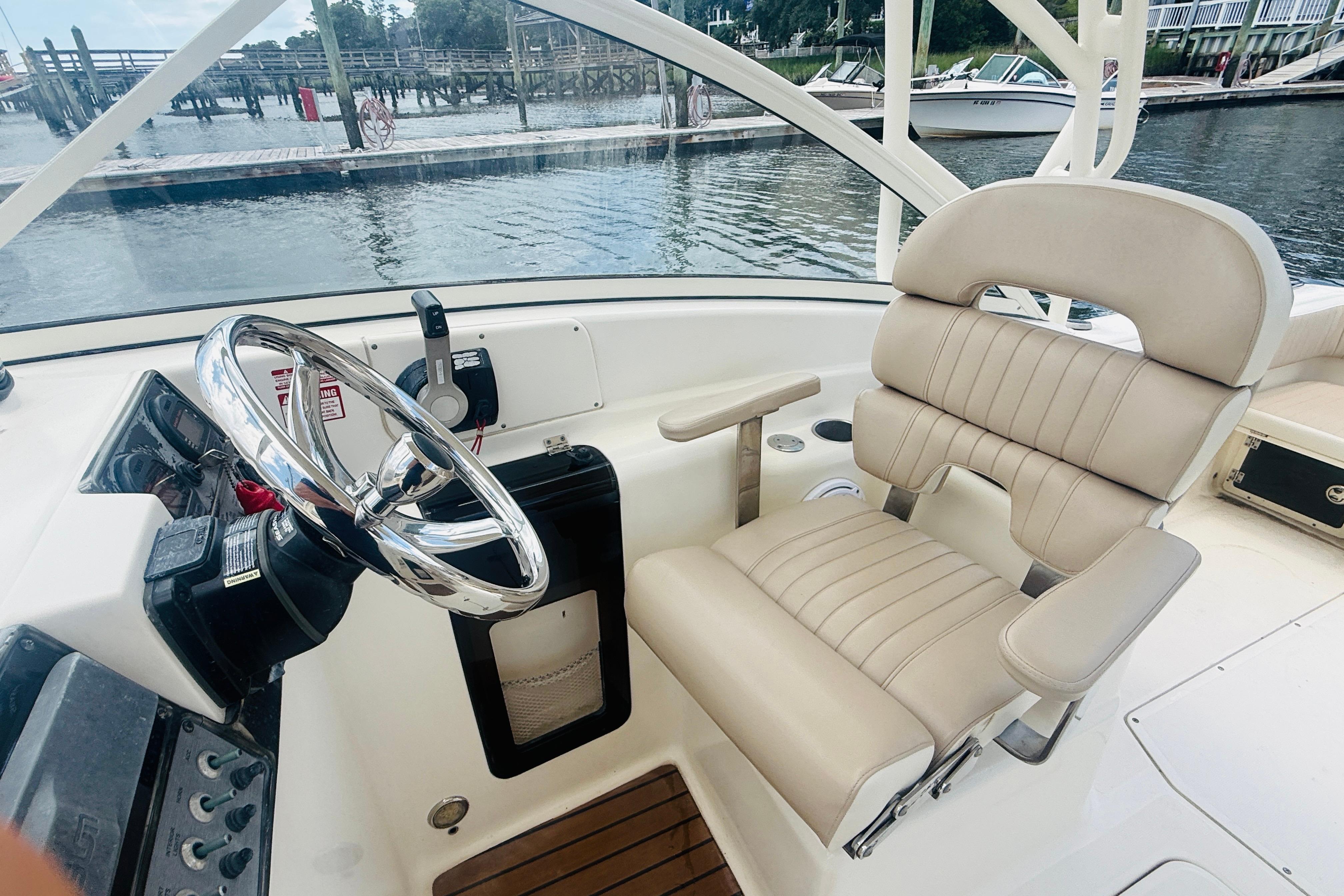 2012 Scout 245 Dorado boat helm with beige captain's chair and steering wheel.