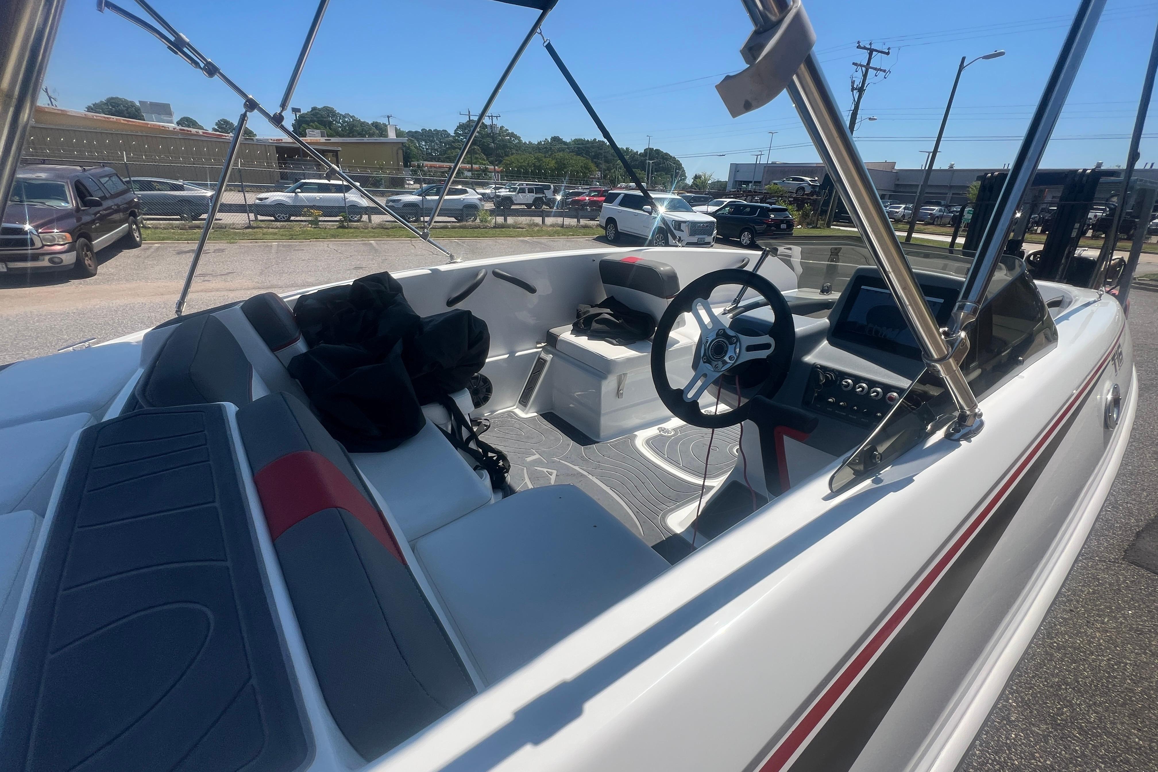 2023 Tahoe T16 boat interior with steering wheel and seating, parked outdoors.