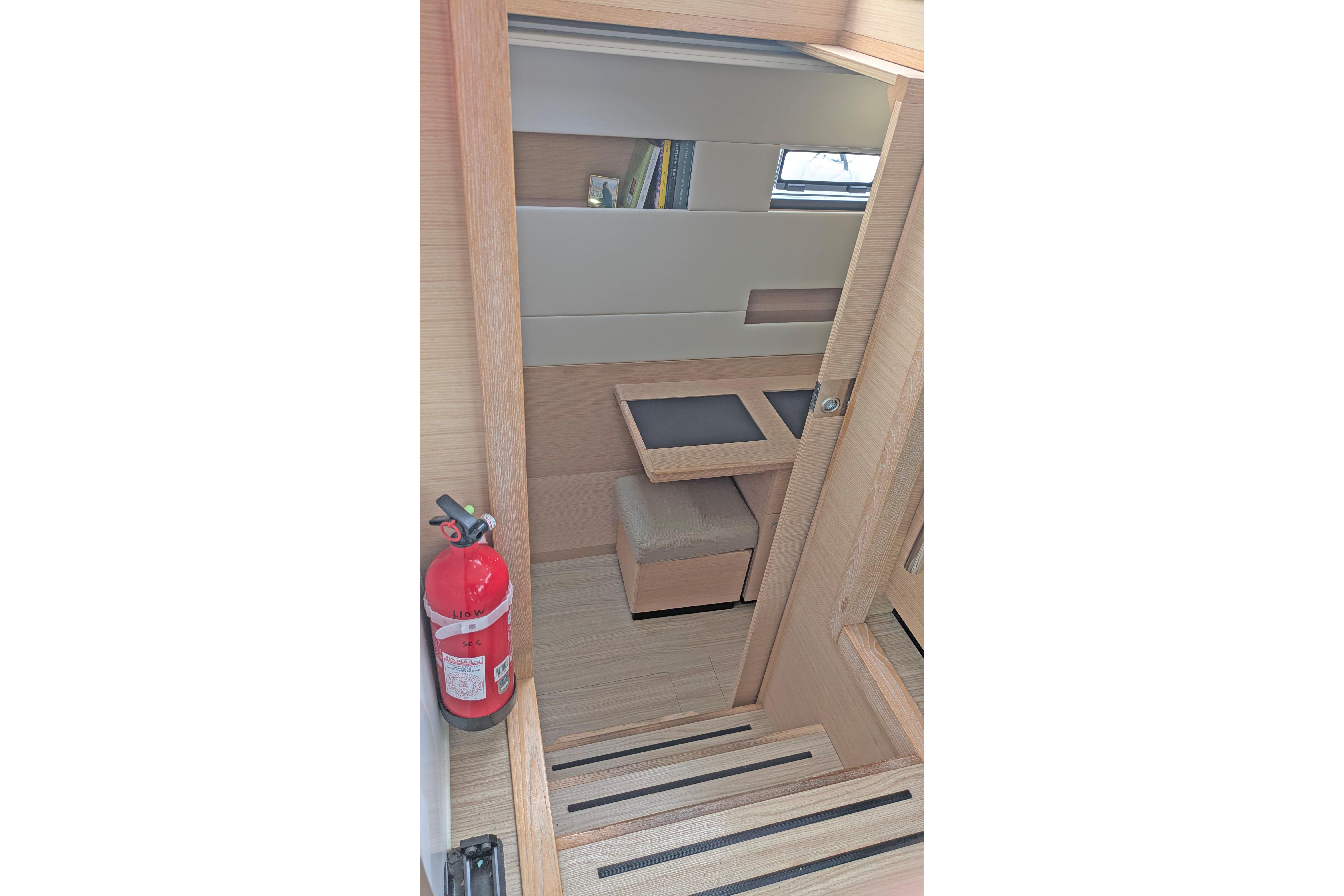 Interior of 2024 Nautitech 40 Open yacht with modern wood finish and fire extinguisher.