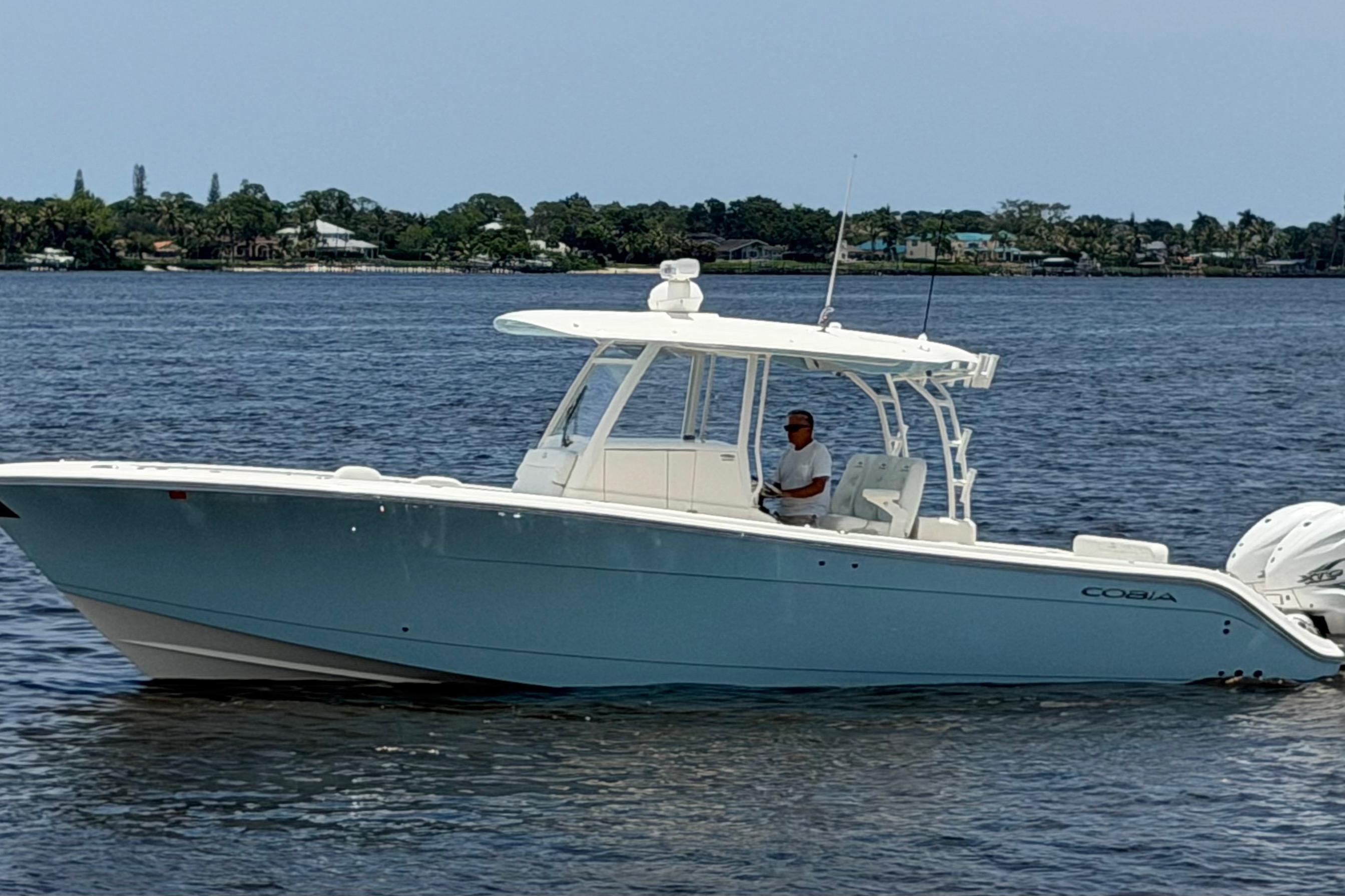 2023 Cobia 350 Center Console boat cruising on a calm waterway.