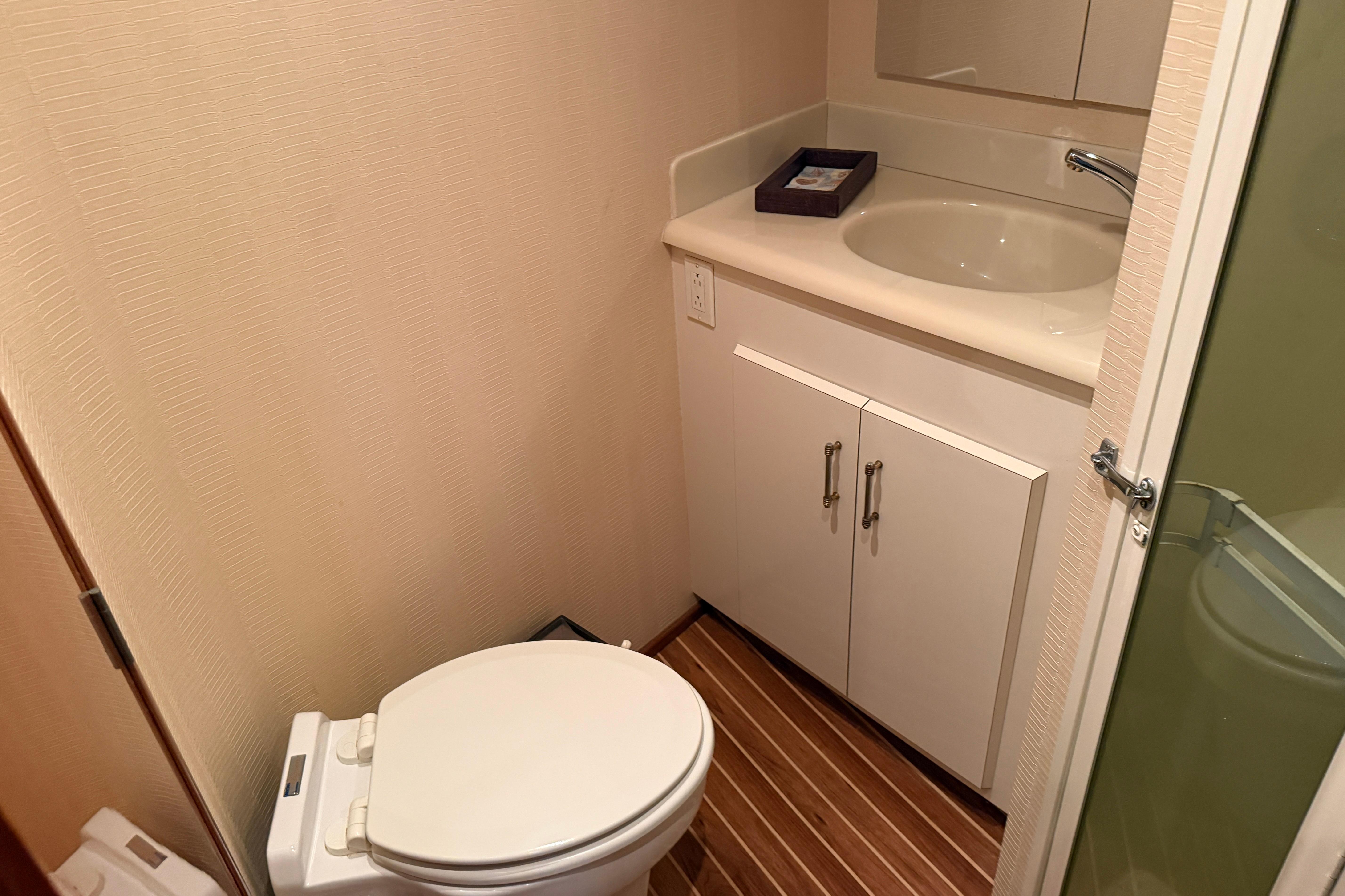 Small bathroom in a 2000 Viking 55 Convertible yacht with toilet and sink.