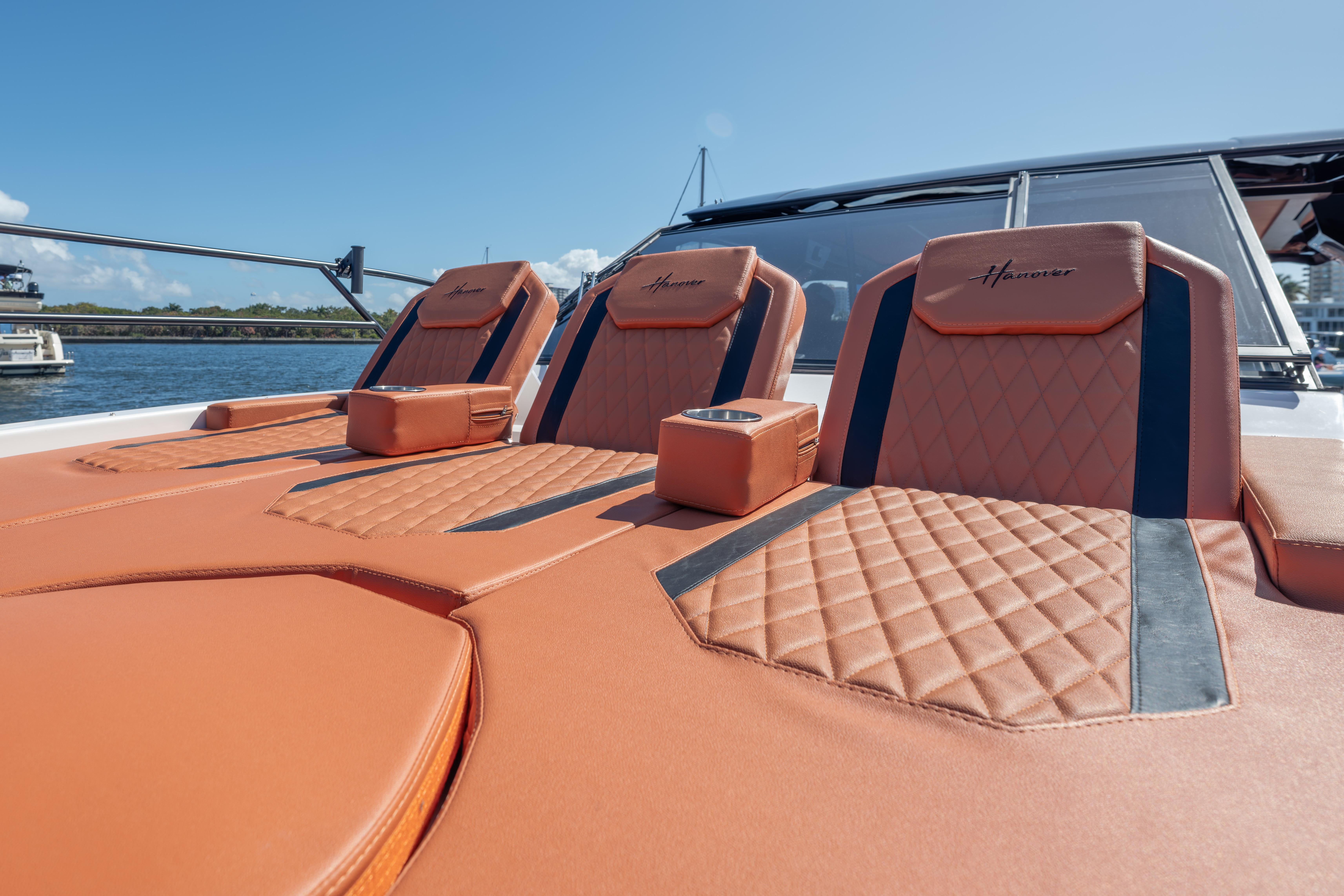 Luxurious seating on 2026 Hanover 387 boat with quilted leather design, docked by the water.