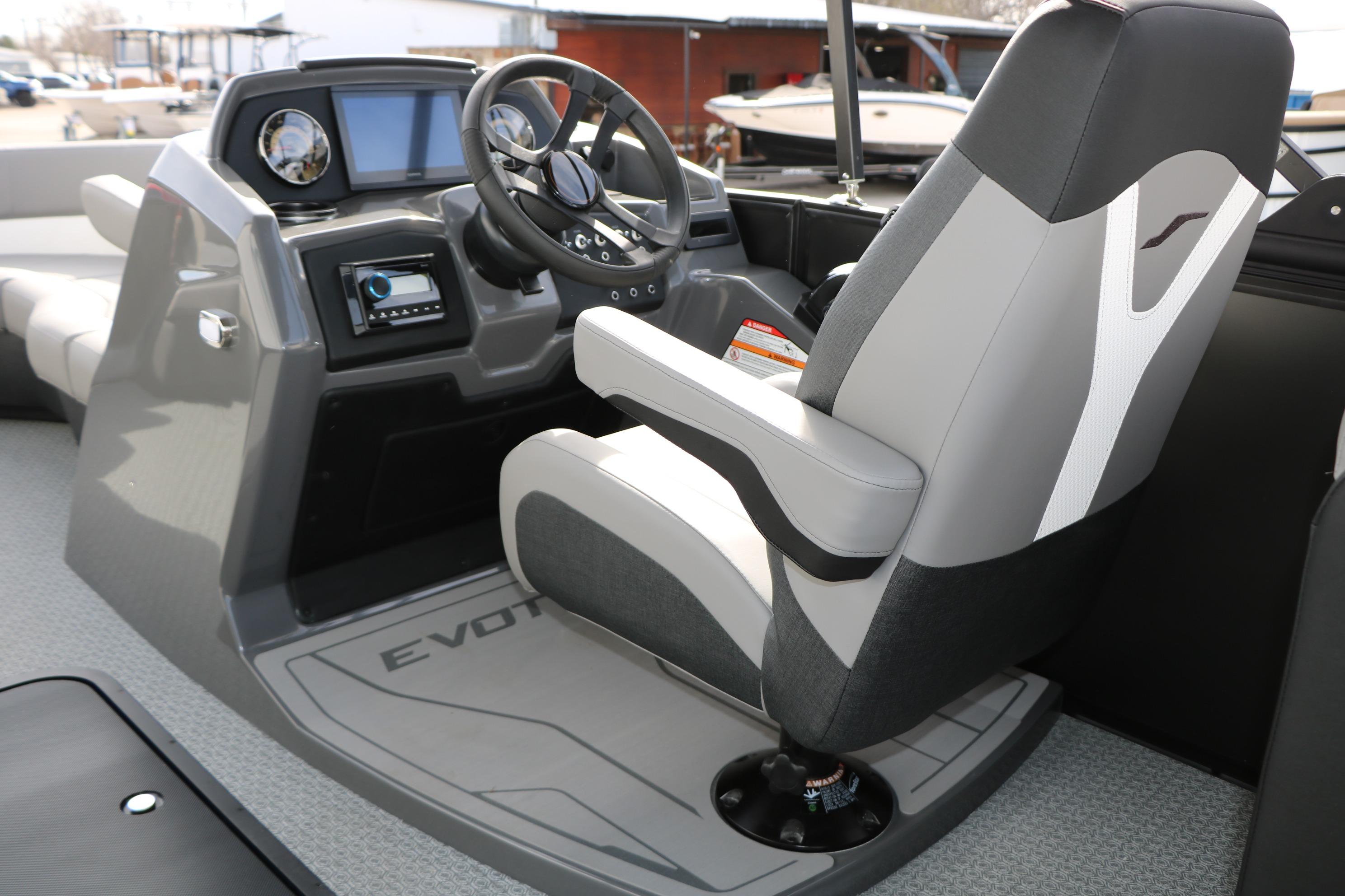 Captain's seat and dashboard of 2026 Evotti 521QL boat, featuring modern controls and steering.
