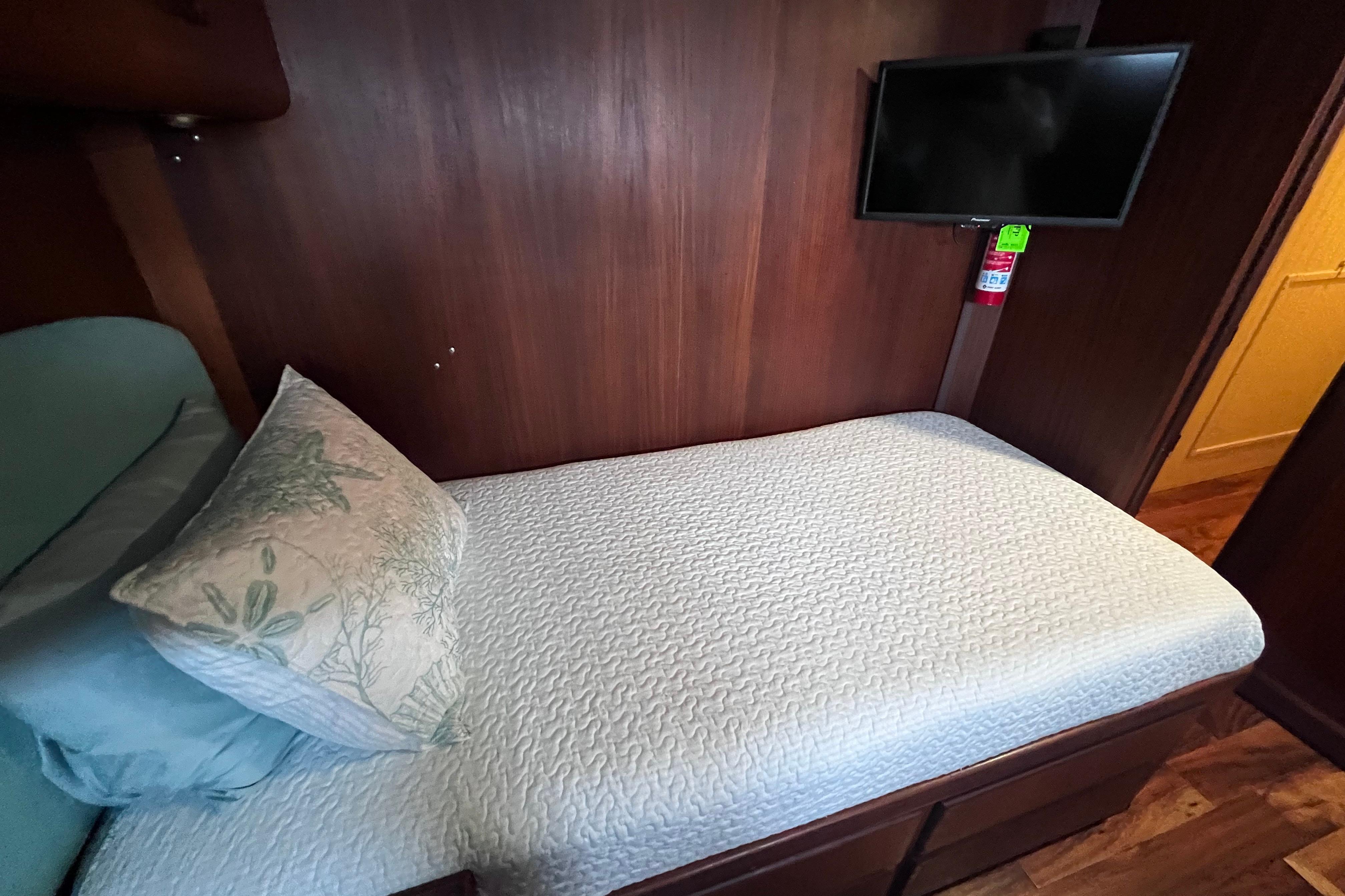 Cozy cabin bed with TV in 1987 Hatteras 70 Cockpit Motor Yacht.