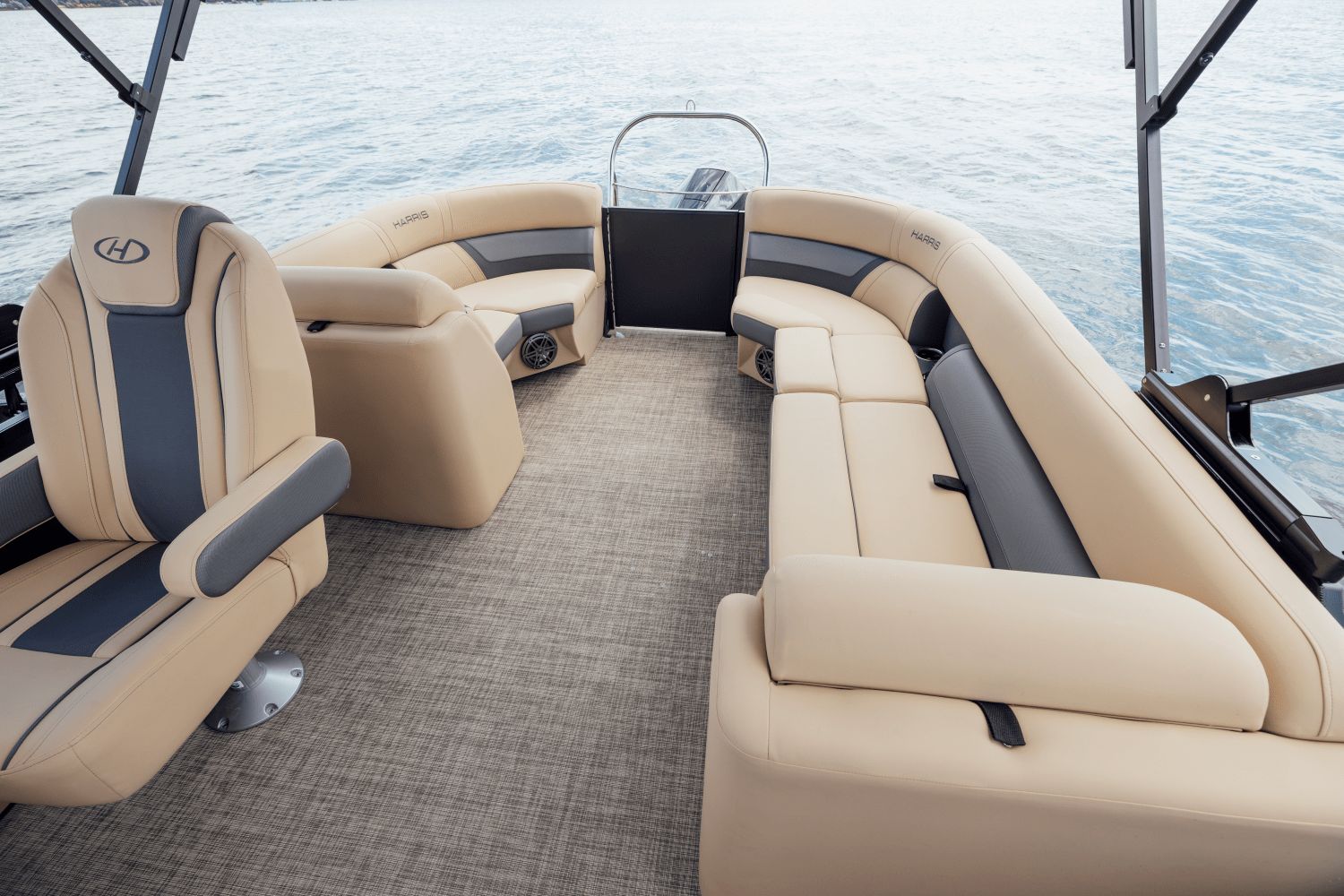 The image shows the interior of a Harris Cruiser 230 pontoon boat with beige seating on the water.