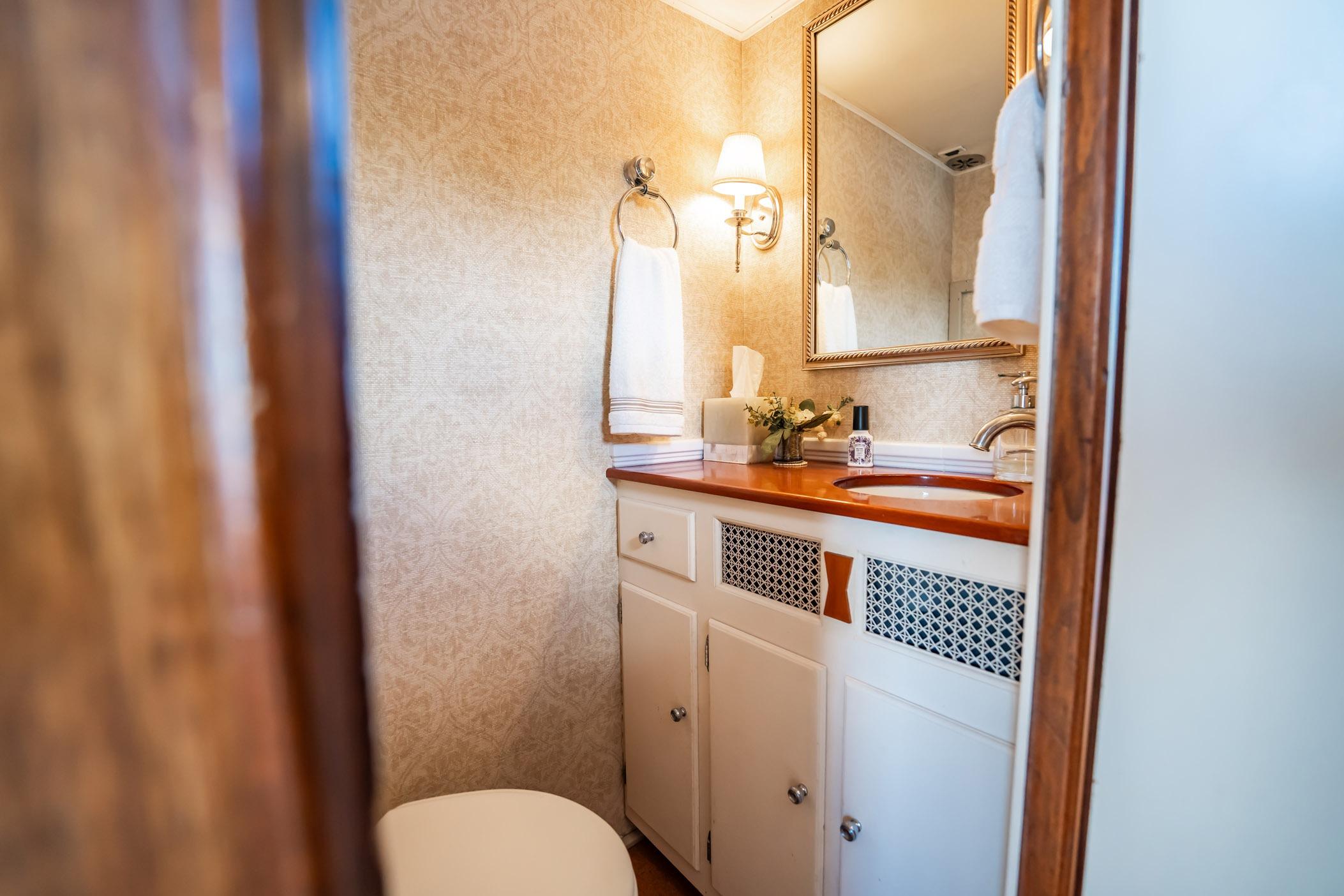 Elegant bathroom interior on 1972 Trumpy 72 Motor Yacht, featuring wooden accents and classic decor.