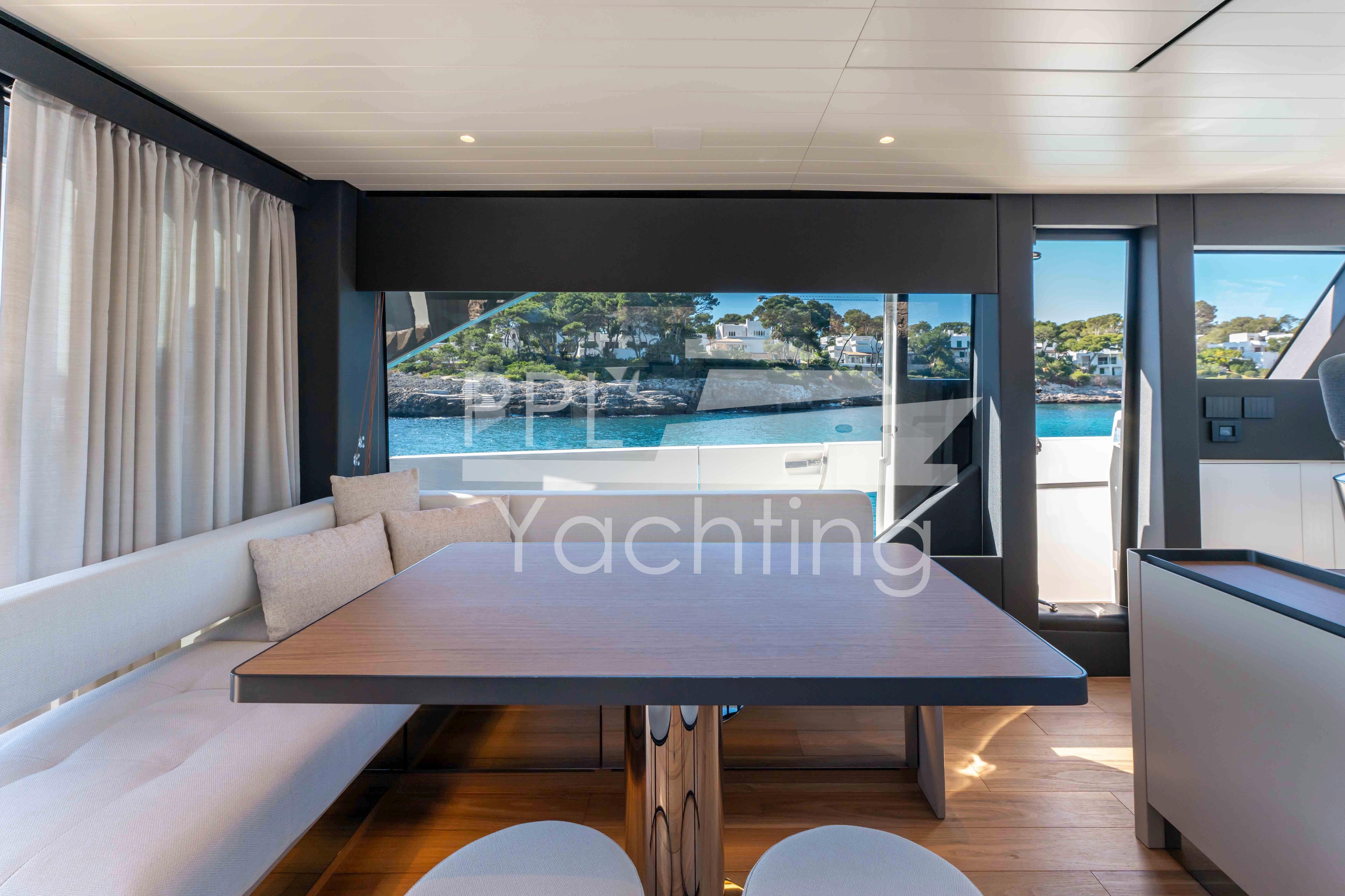 Interior of 2024 Bluegame BGX63 yacht with elegant dining area and scenic ocean view.
