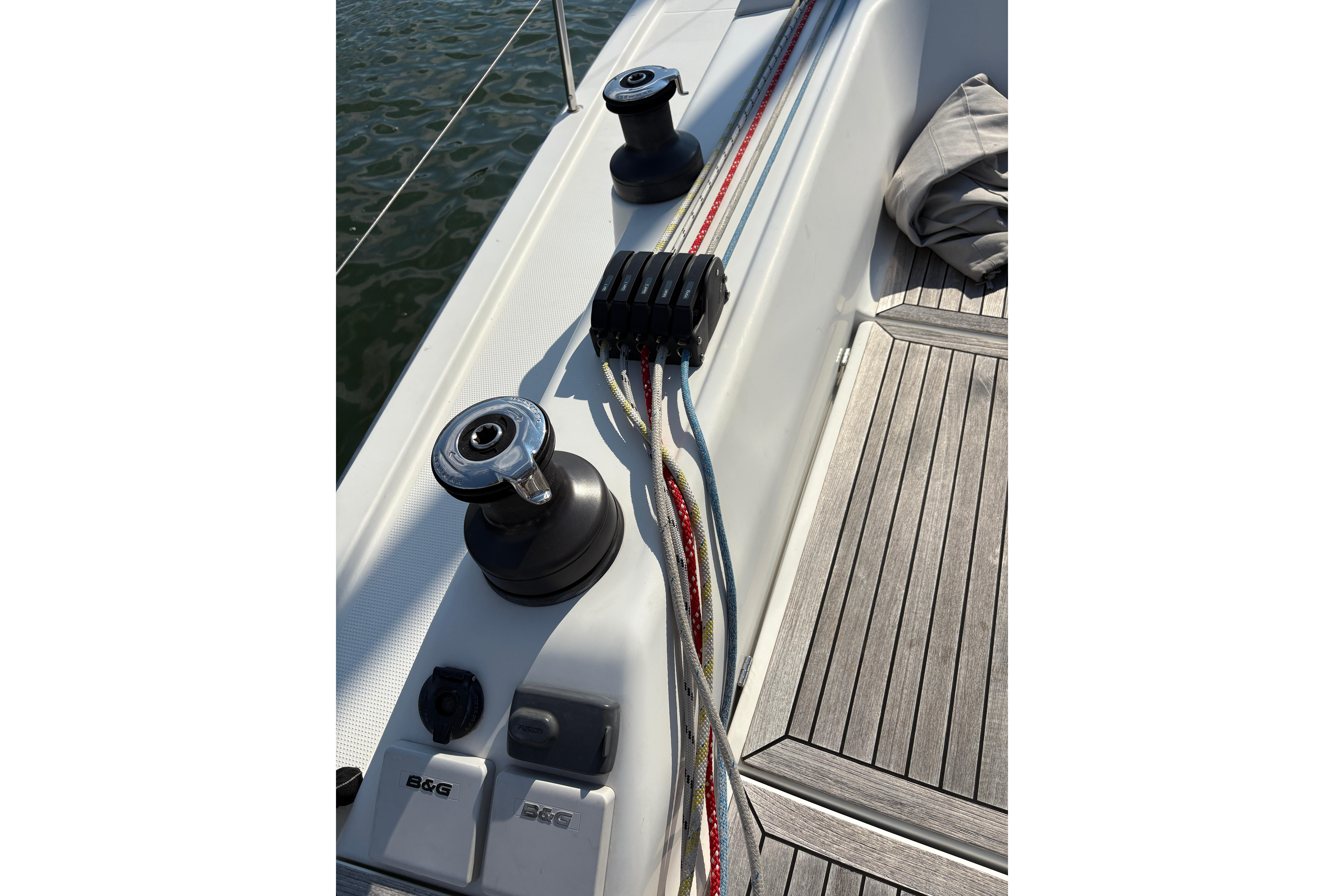 Deck of 2014 Hanse 415 sailboat with winches and colorful ropes.