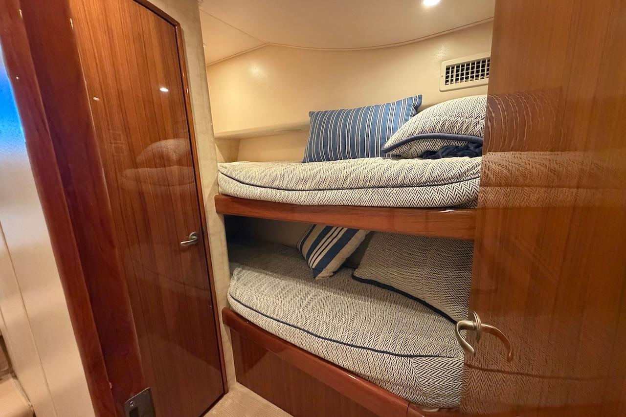 Bunk beds in a 2012 Viking 50 Convertible yacht cabin with wooden finishes.