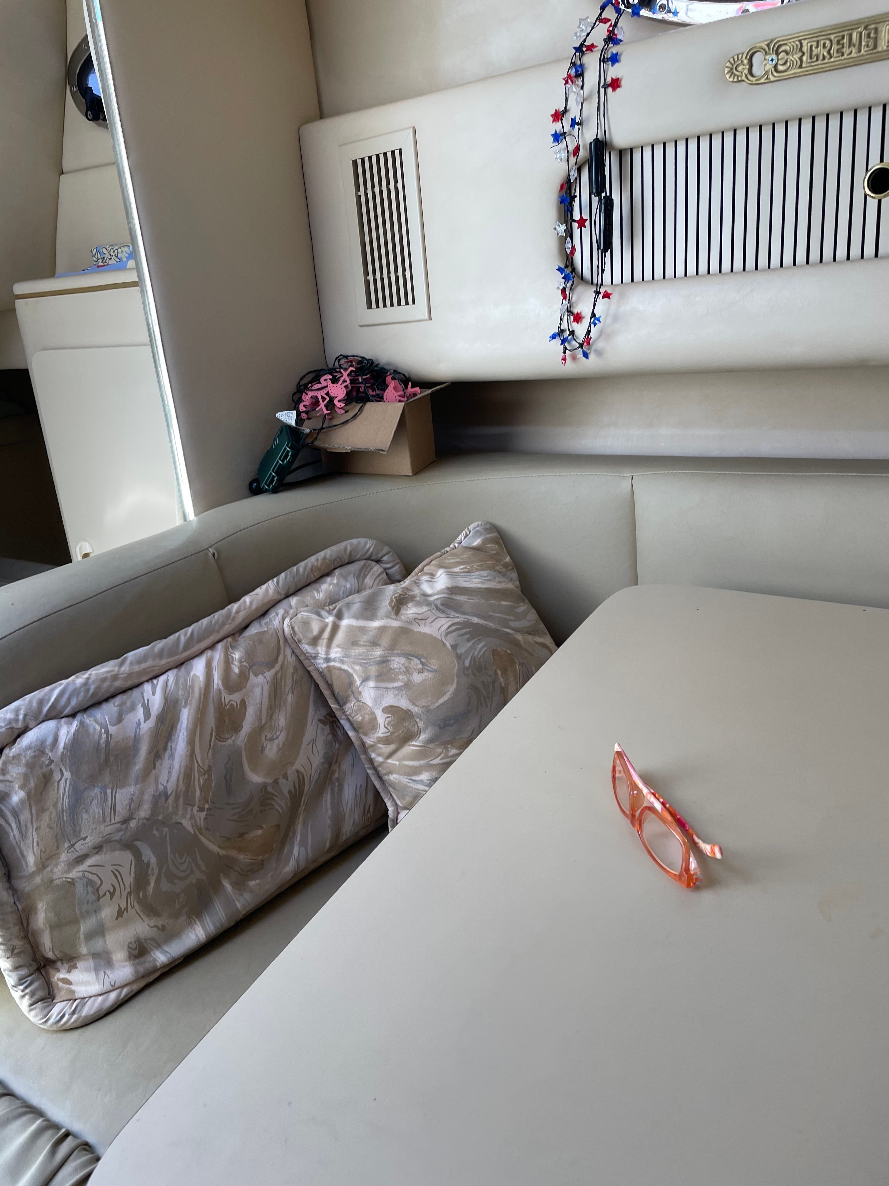 Interior of a 1998 Sea Ray 270 Sundancer with cushions and a table.