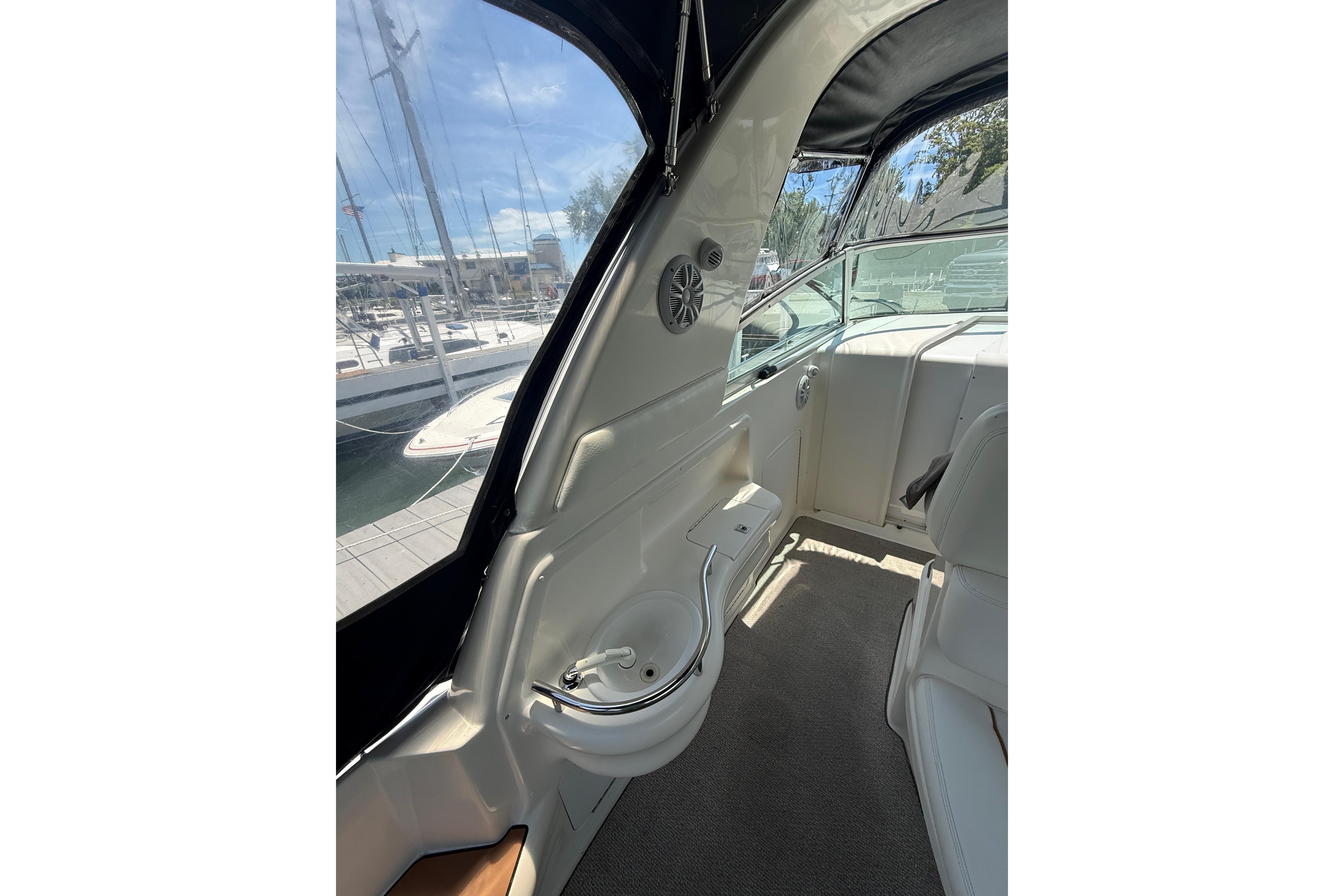 Interior view of 1999 Sea Ray Sundancer 310 yacht with seating and marina backdrop.
