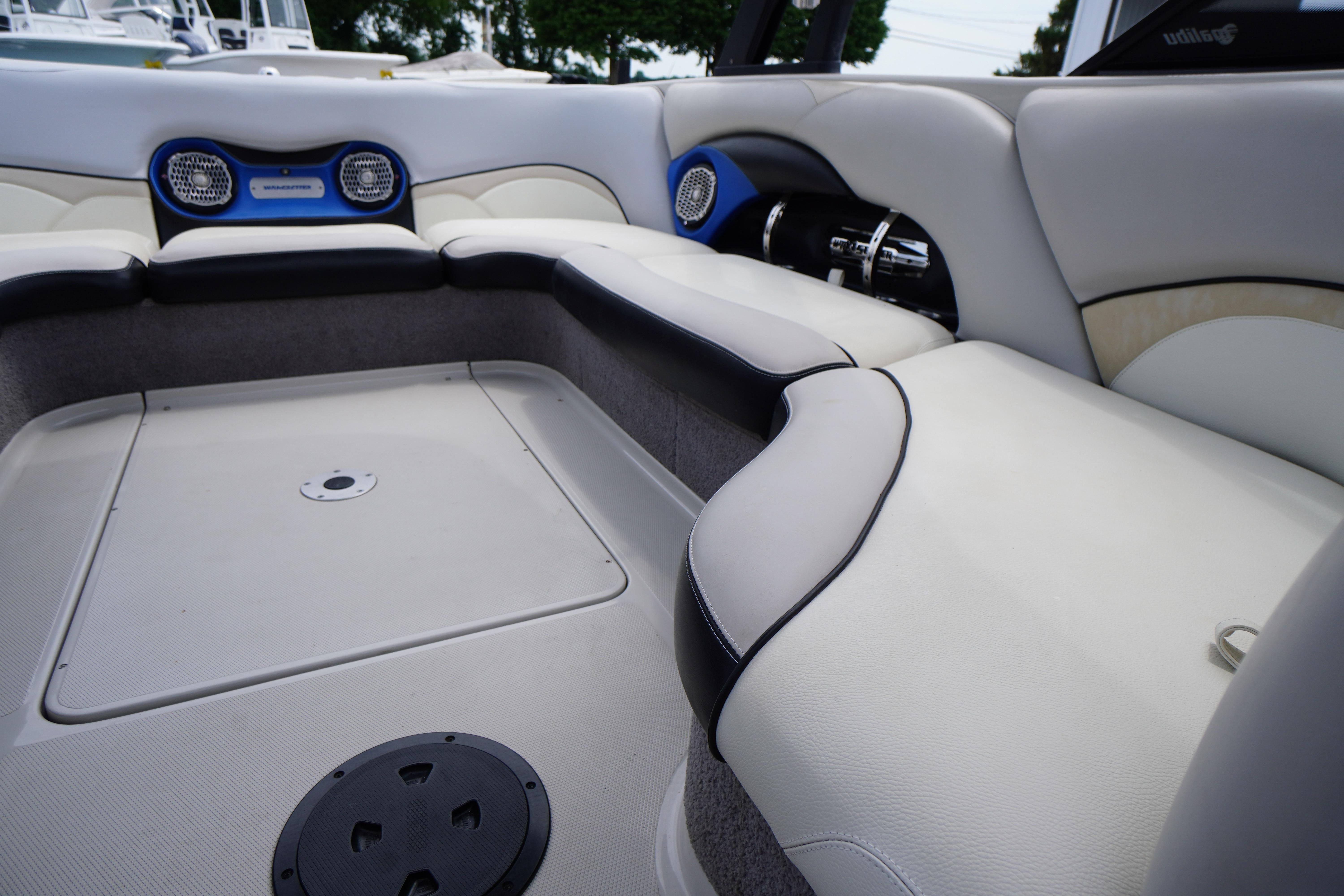Interior of 2011 Malibu Wakesetter 21 VLX boat with white seating and speakers.