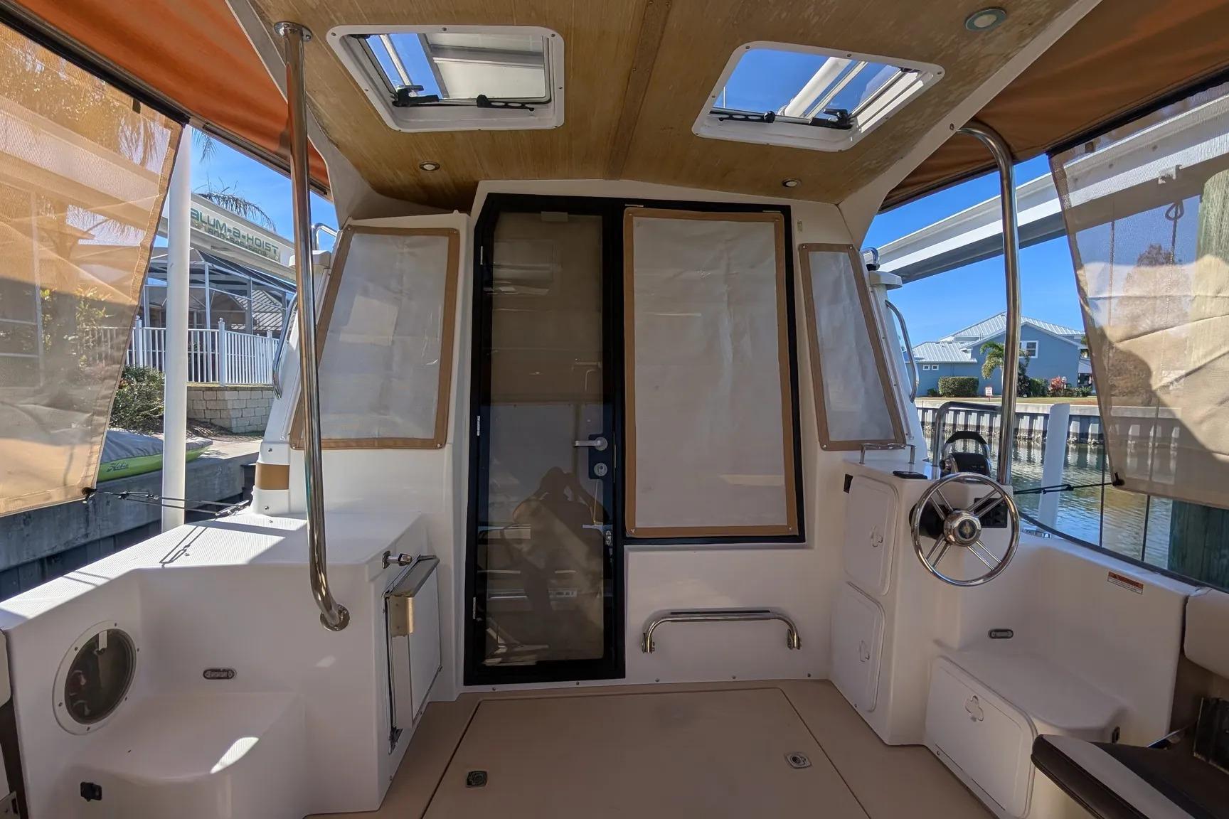 2015 Ranger Tugs R-29 S boat interior with helm, skylights, and dockside view.