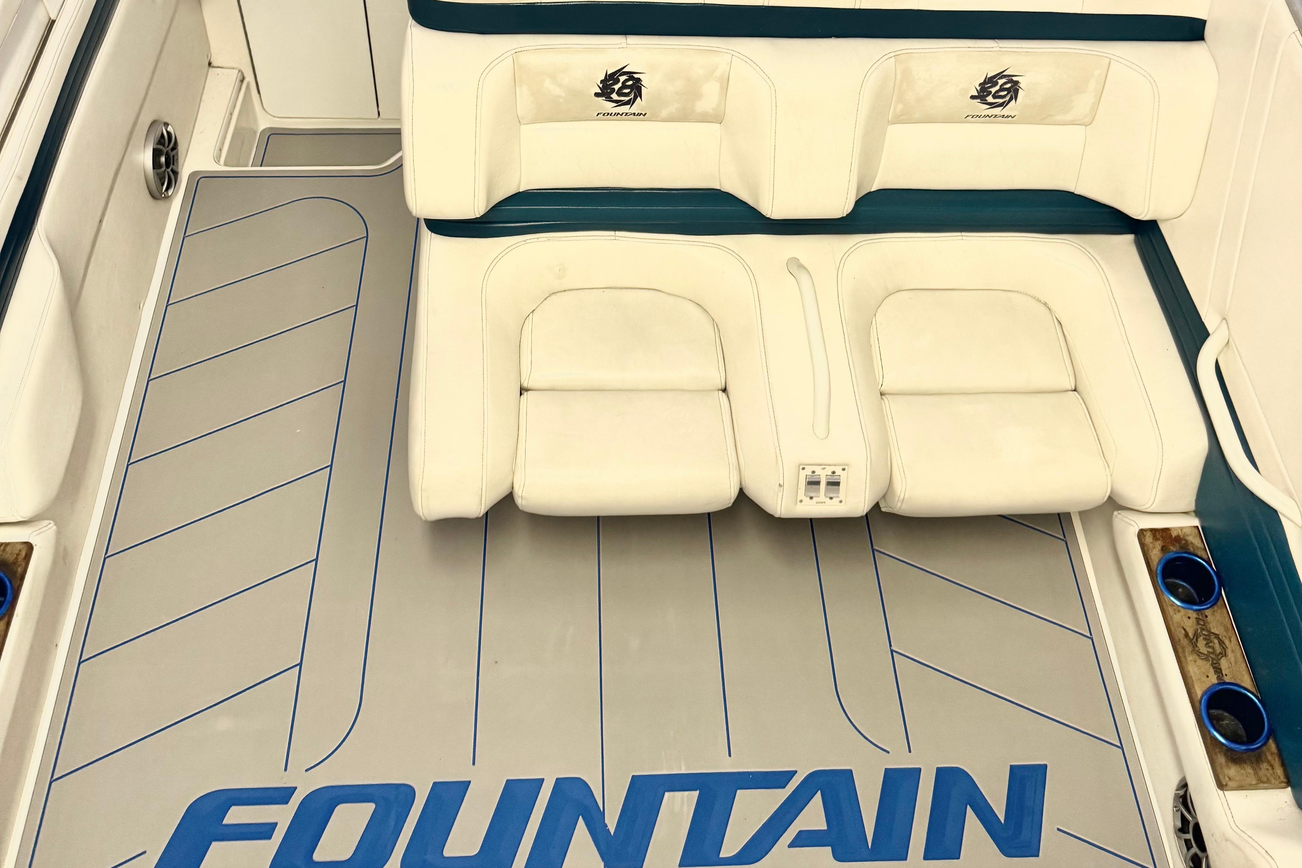 1999 Fountain 38 SC boat interior with white seating and branded flooring.