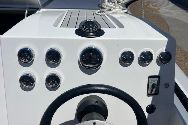 Steering console of 2024 Bracewell 25 boat with gauges and compass.