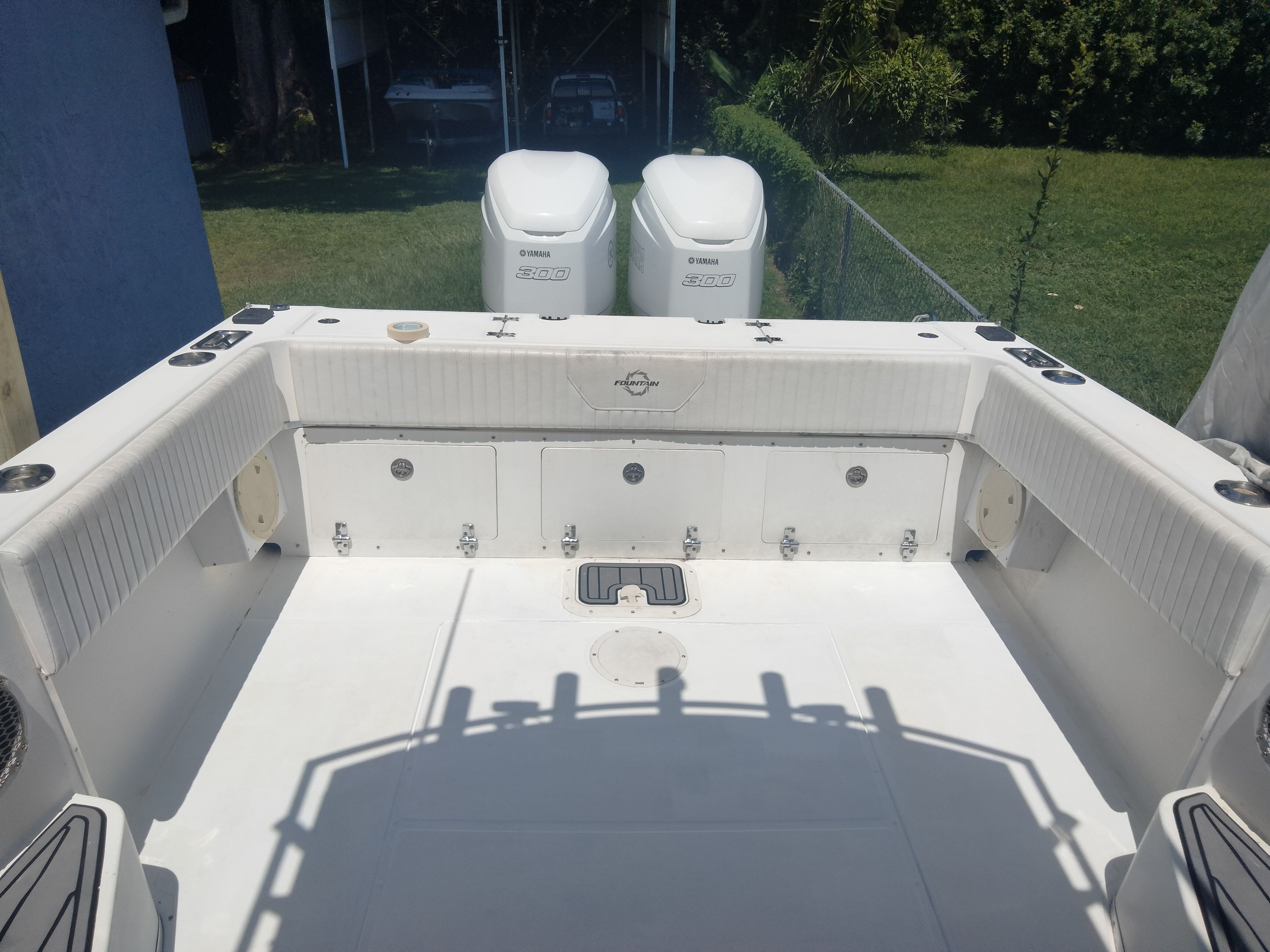 The image shows the spacious aft deck of a boat with two outboard engines.
