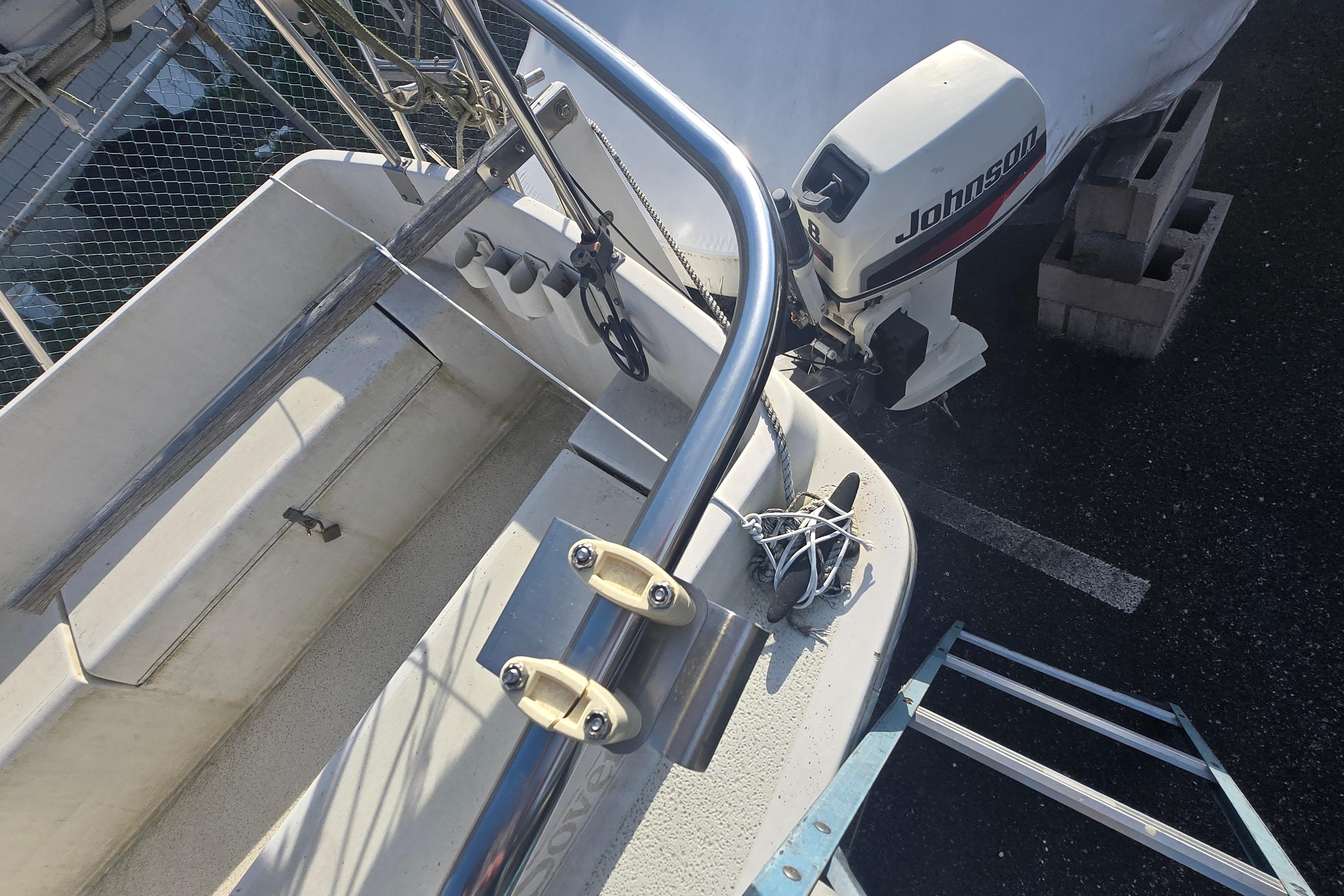 1986 Sovereign 24 sailboat with Johnson outboard motor, docked and secured.