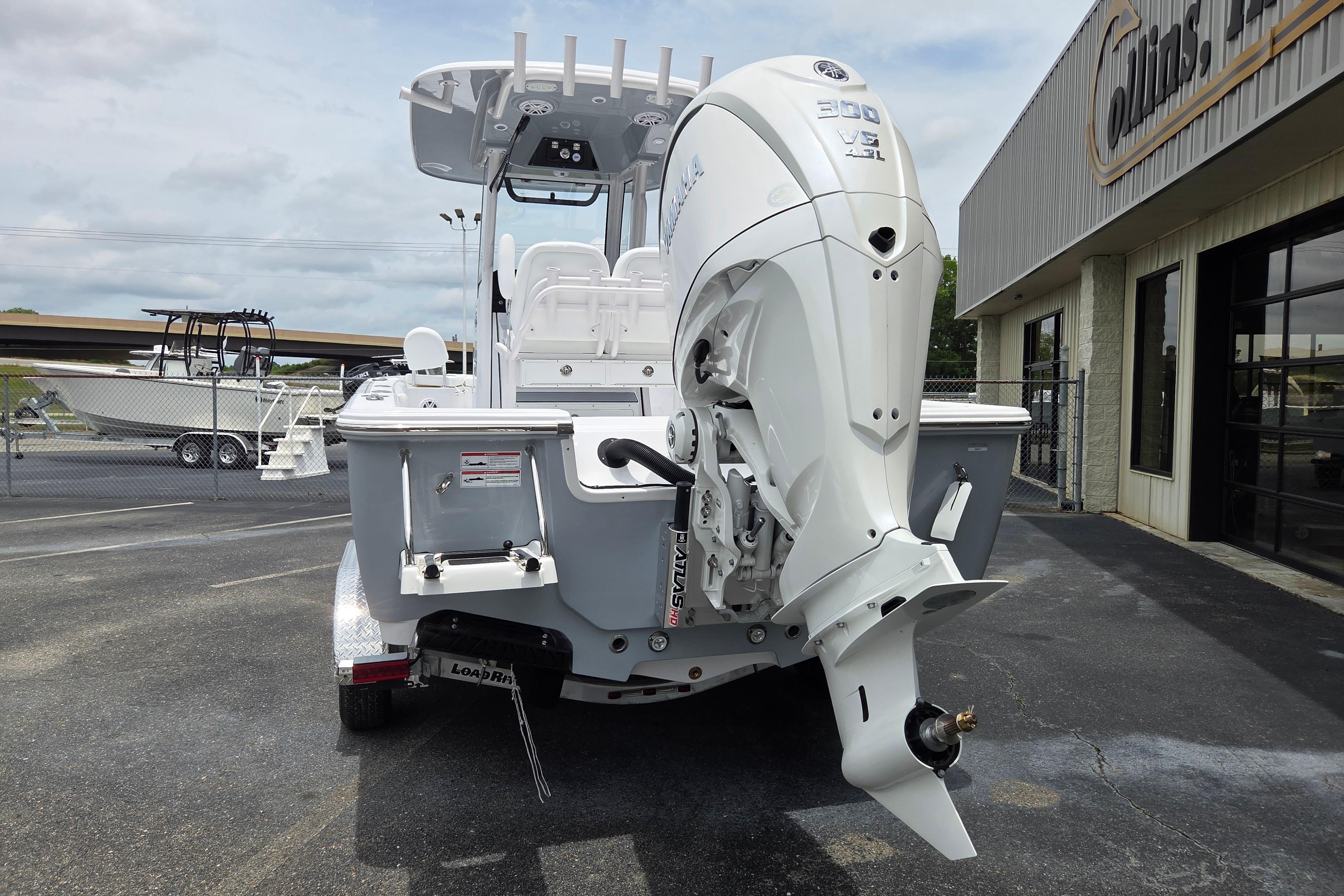 2026 Sportsman Masters 247 Bay Boat with powerful outboard motor, parked outside dealership.