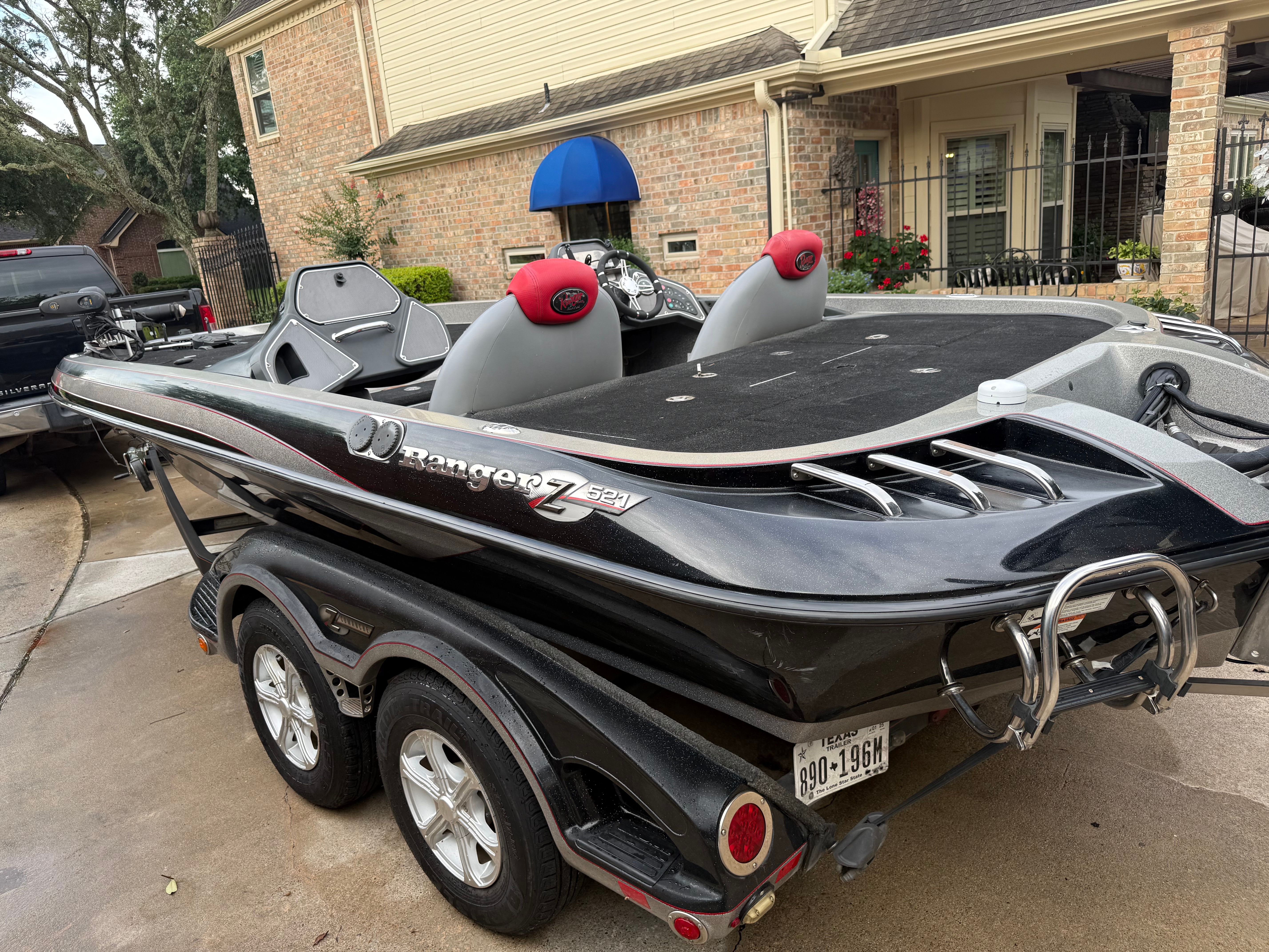 A 2011 Ranger Z521 Comanche on a trailer in front of a brick house.