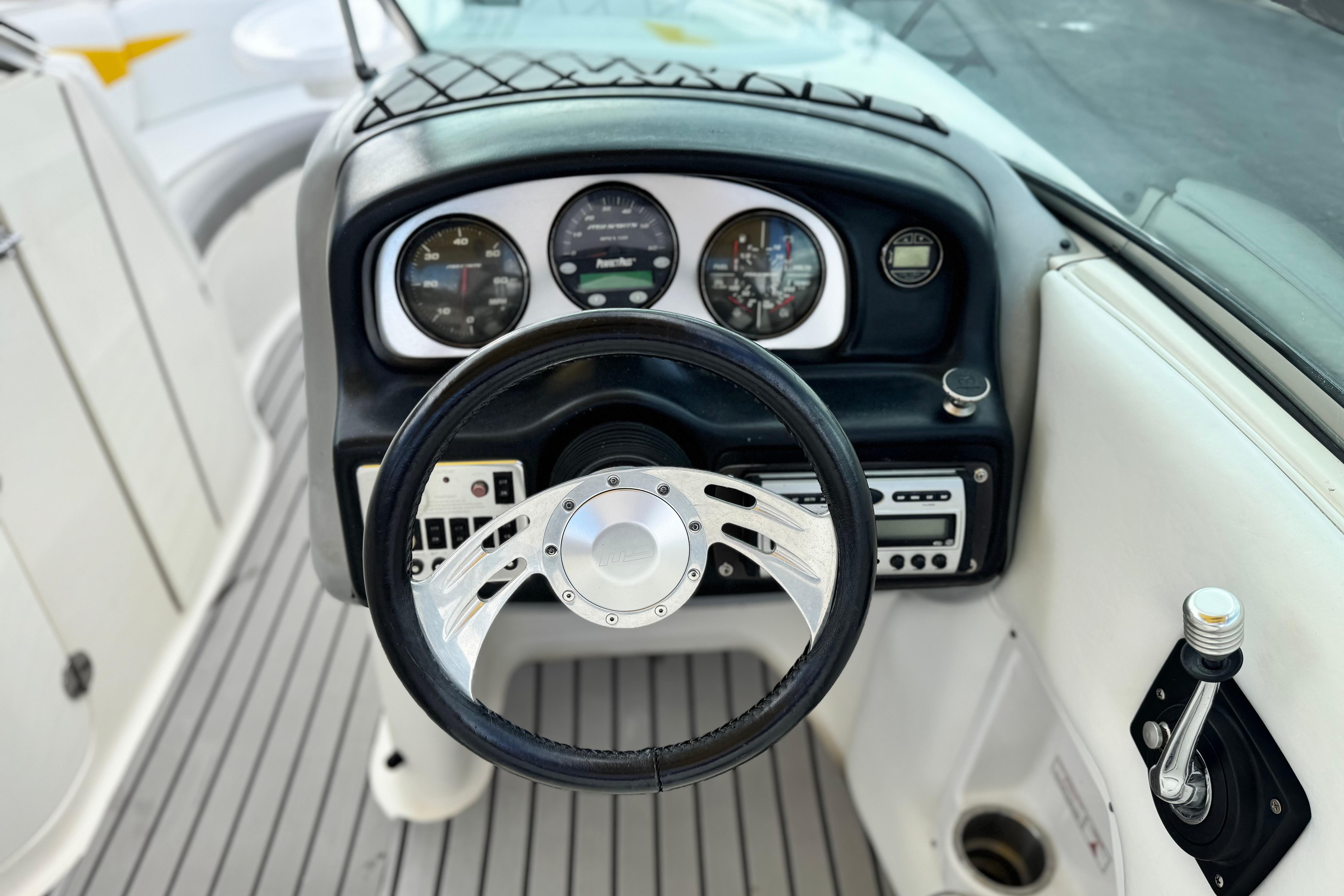 Steering console of 2005 MB 240 V Sportdeck boat with gauges and controls.