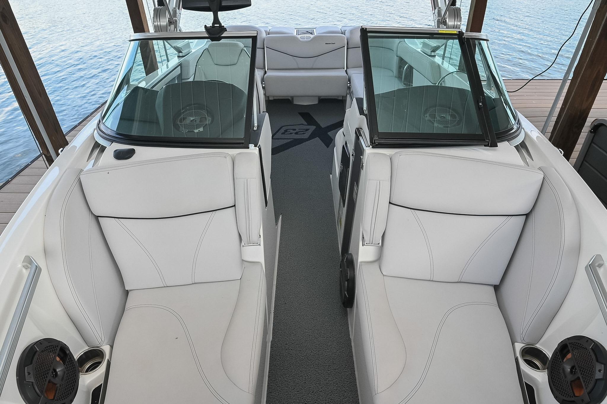 2018 MasterCraft X23 boat interior with white seating and glass windshields.