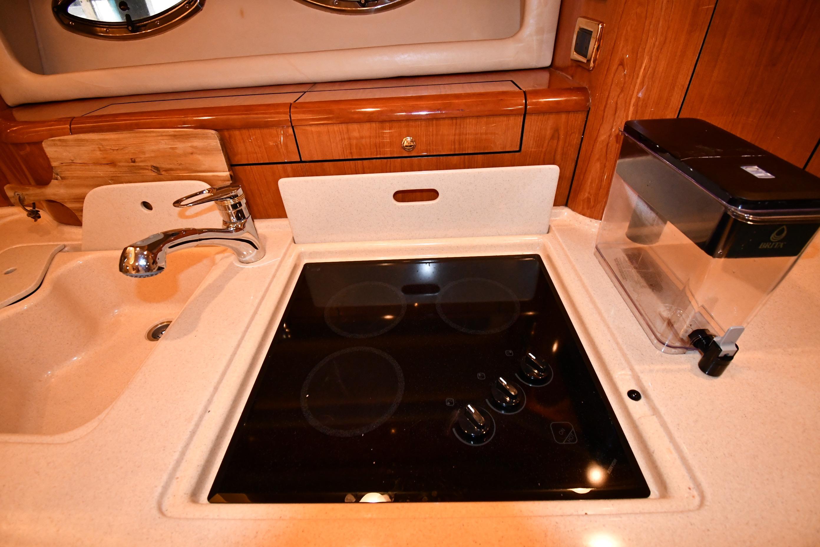 2001 Sea Ray 540 Sundancer kitchen with stove, sink, and water filter.