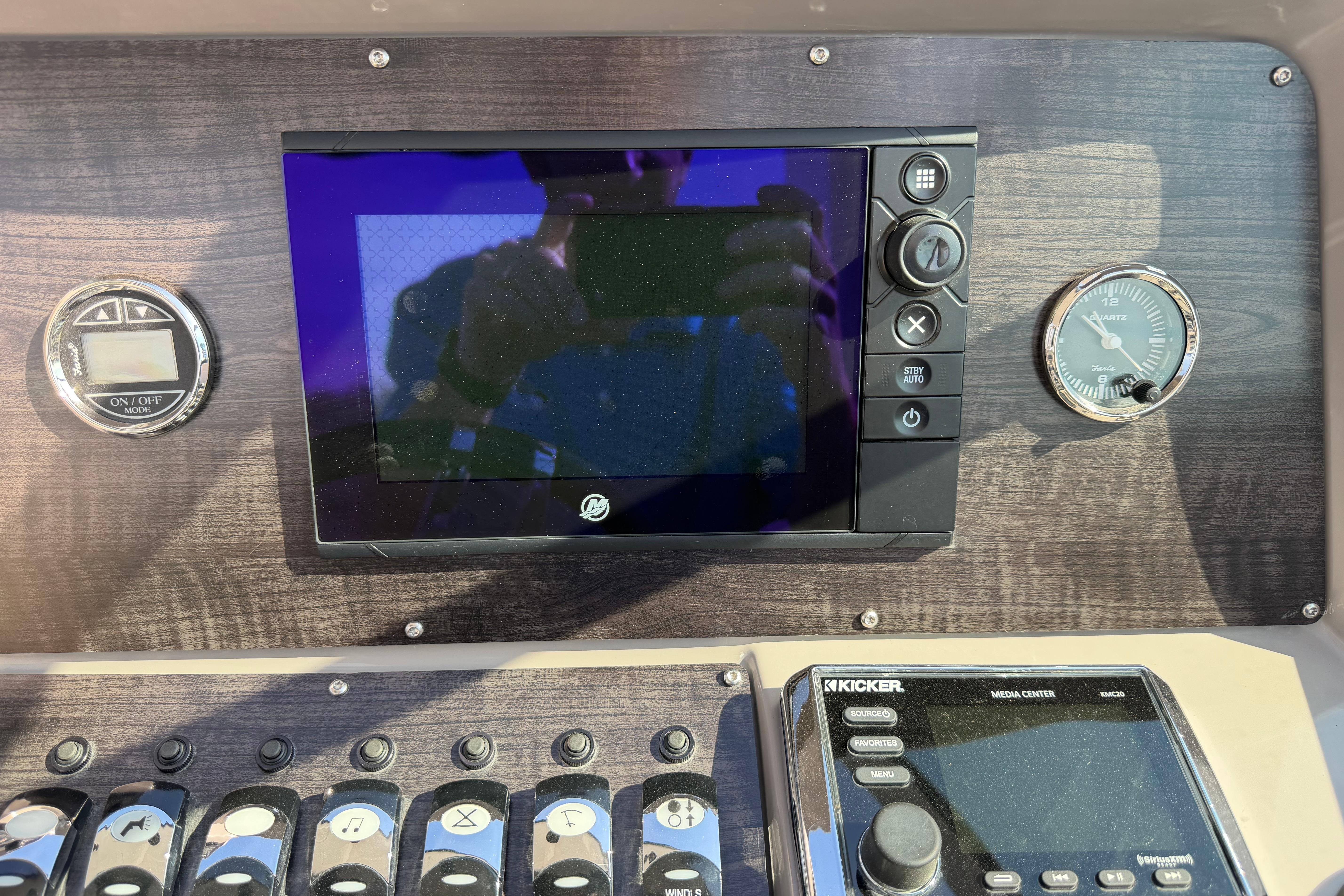 Control panel of a 2019 Rinker EX 320 boat with navigation and media systems.