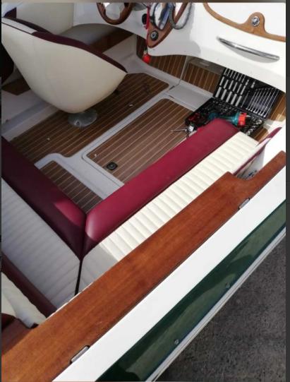 Interior of 2006 Quicksilver Classic 20 boat with wood accents and maroon seating.