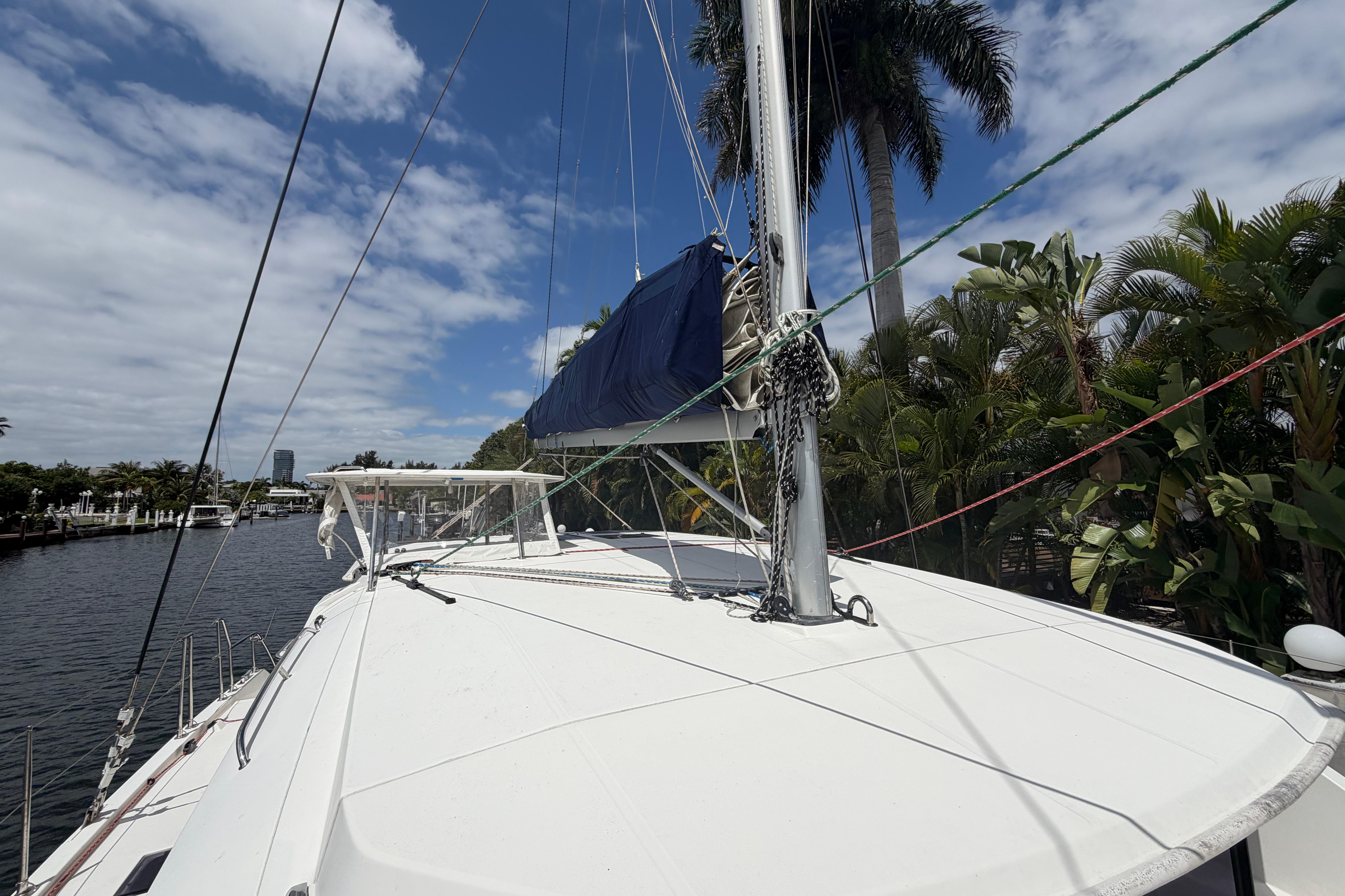 2018 Leopard 40 catamaran docked by palm trees under a partly cloudy sky.