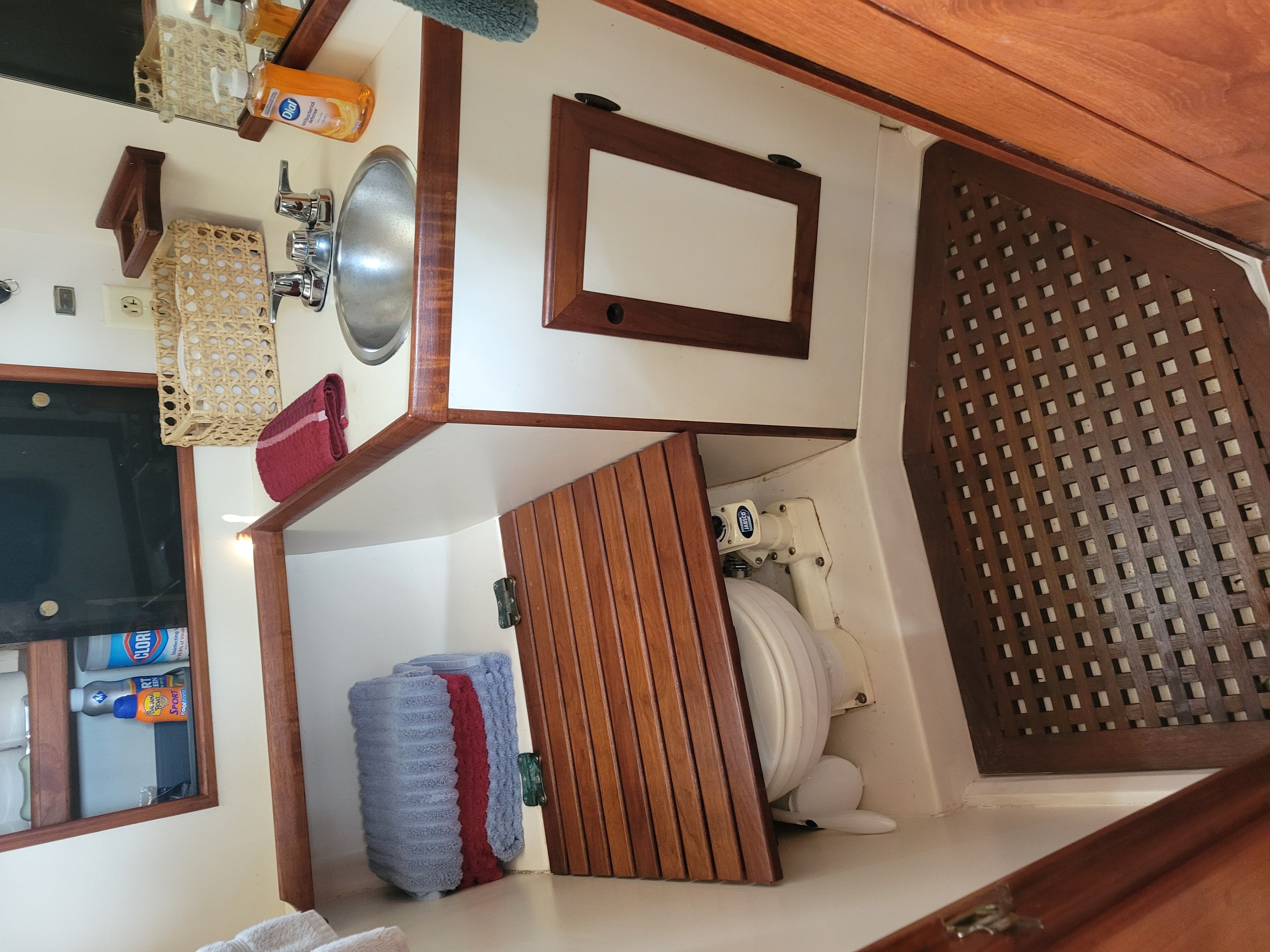 The image shows the bathroom of a 1989 Cape Dory MS300 with wood paneling and a sink.