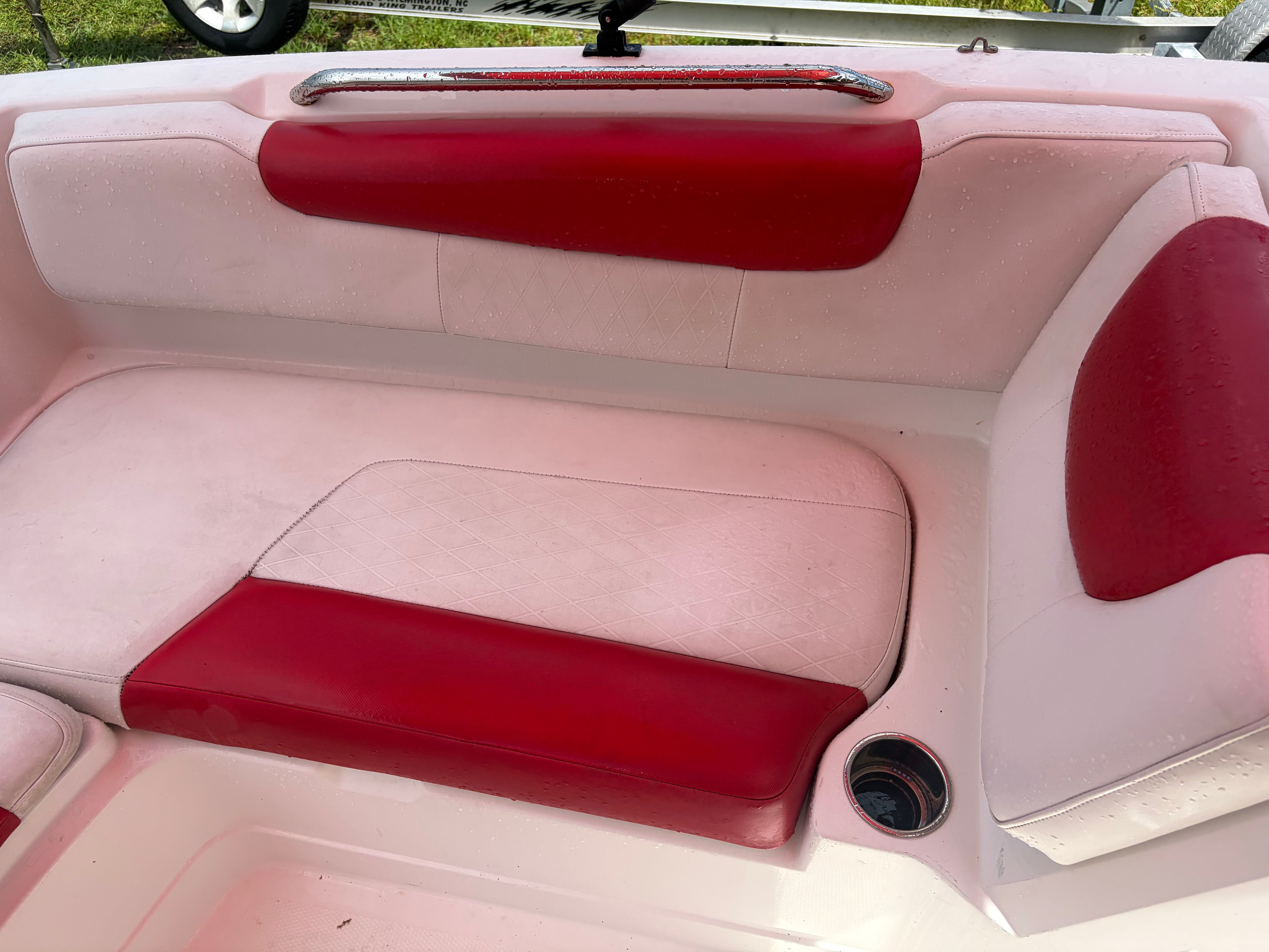 Red and white upholstery on a boat seat with a cup holder.