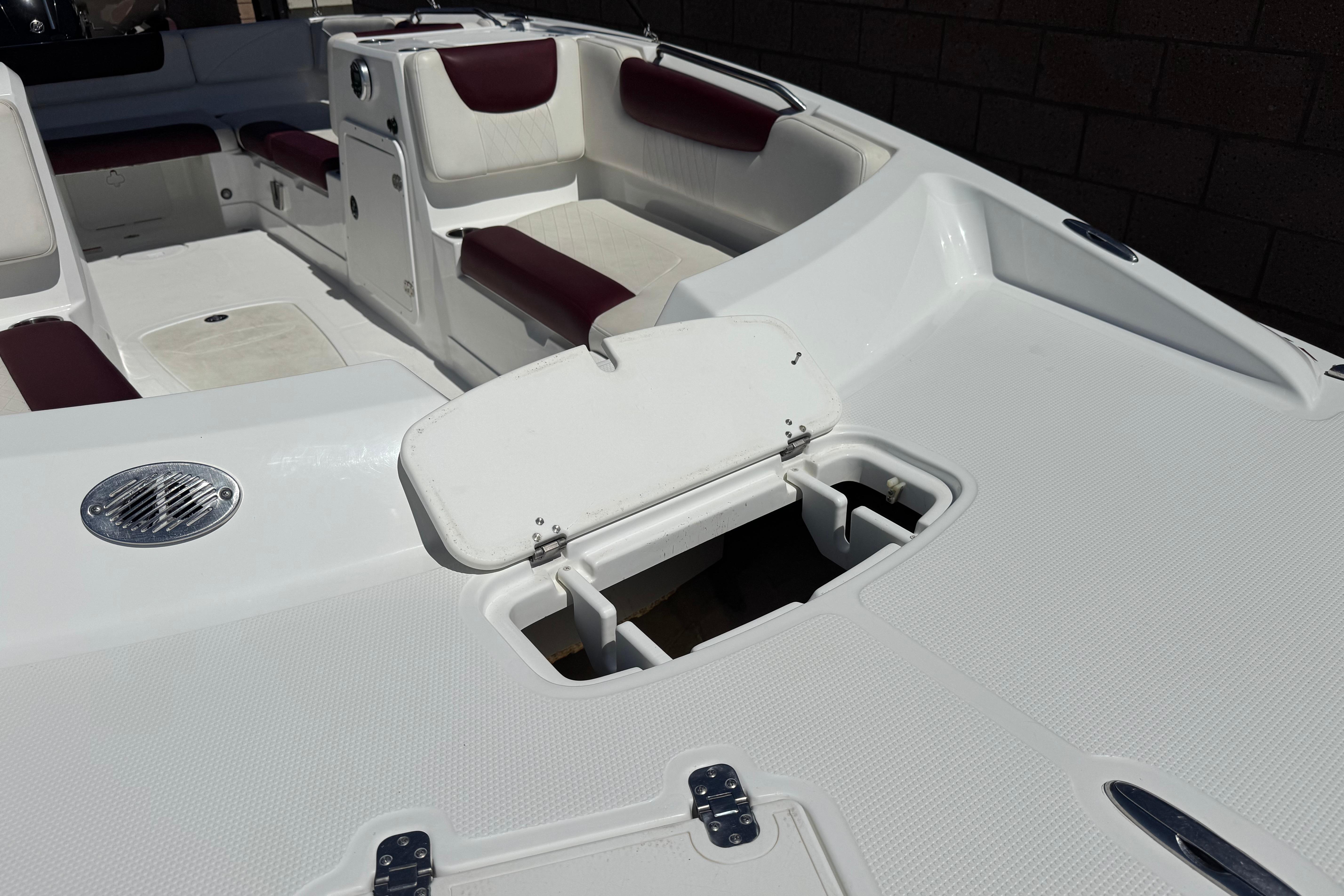 2017 Tahoe 2150 boat interior with white and maroon seating, open storage compartment.