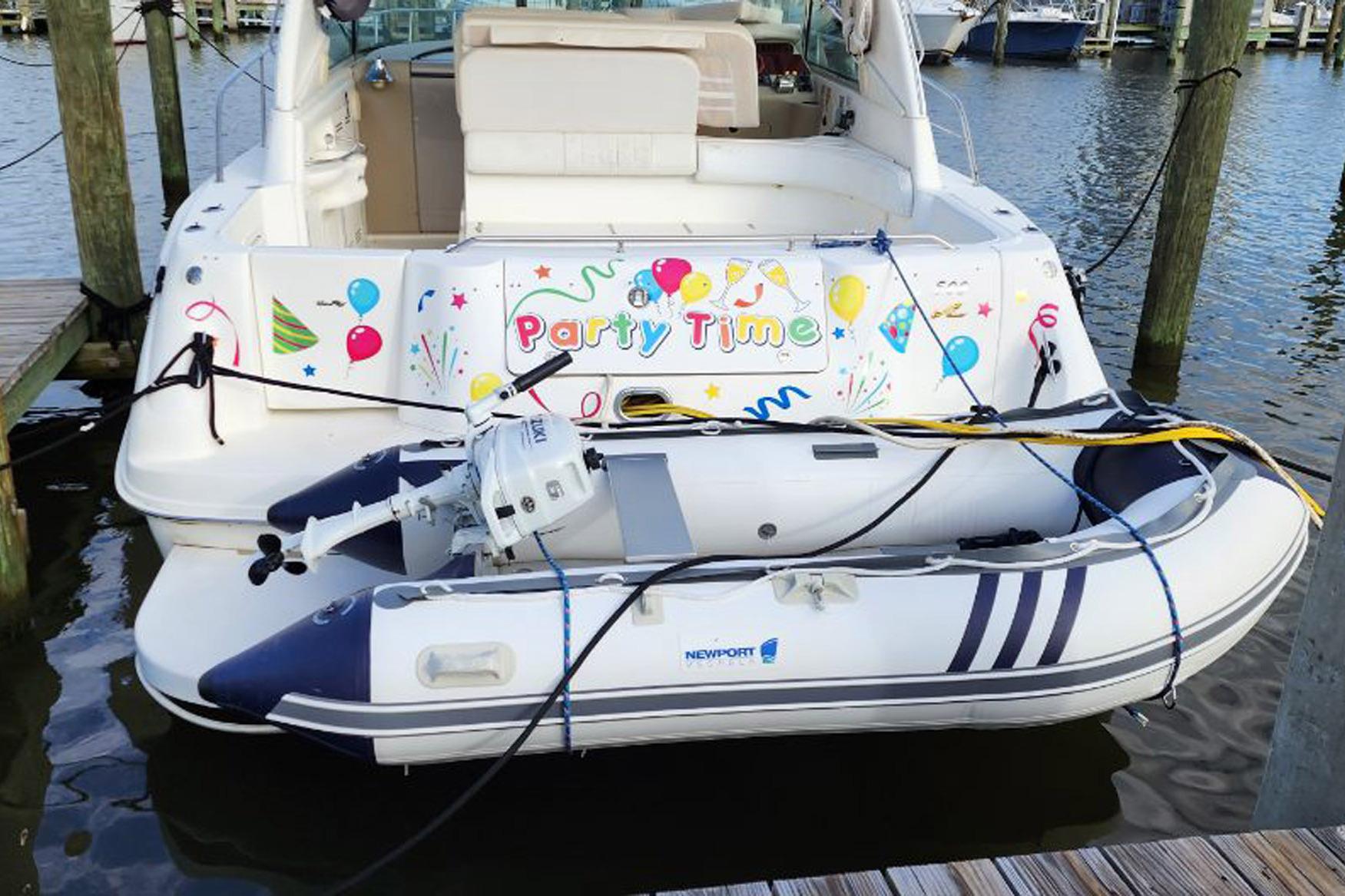 1998 Sea Ray Sundancer 400 with festive "Party Time" decorations and an inflatable boat.