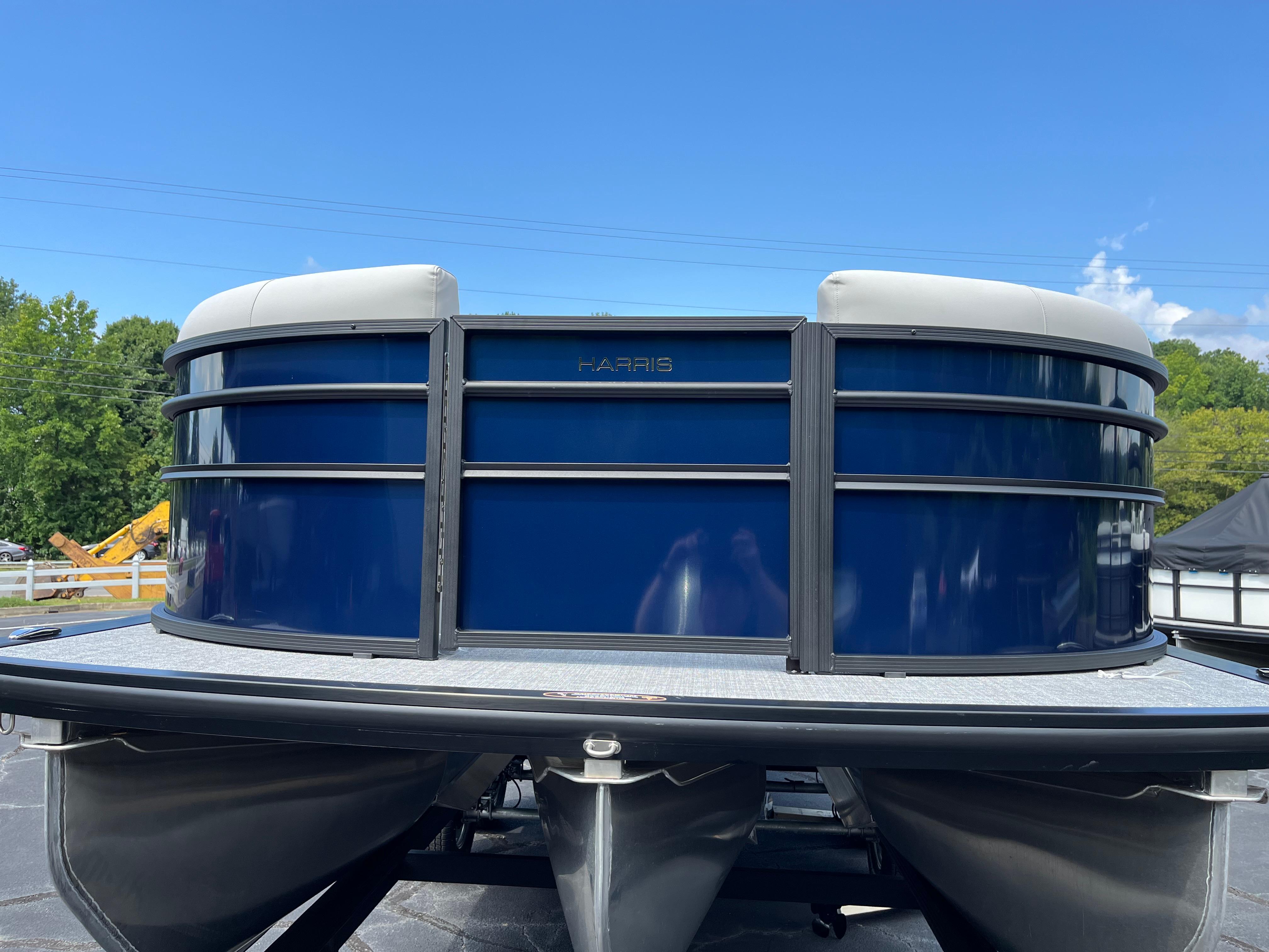 2026 Harris Cruiser 210 pontoon boat with sleek blue exterior under clear sky.