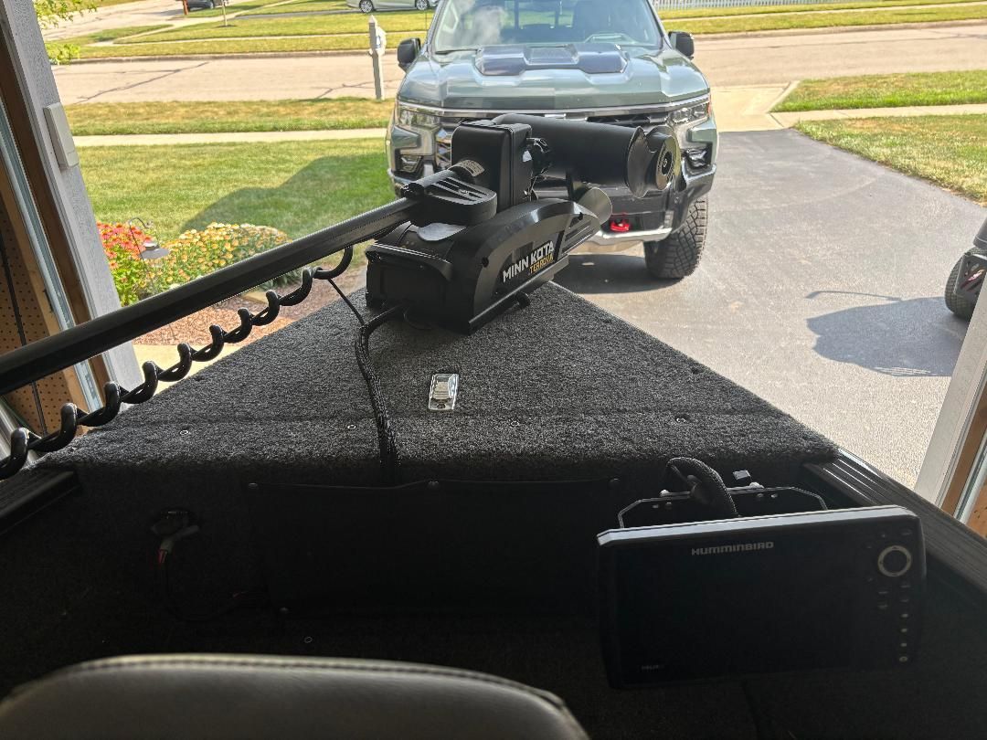 A boat with a Minn Kota motor and Humminbird device, parked in a garage.