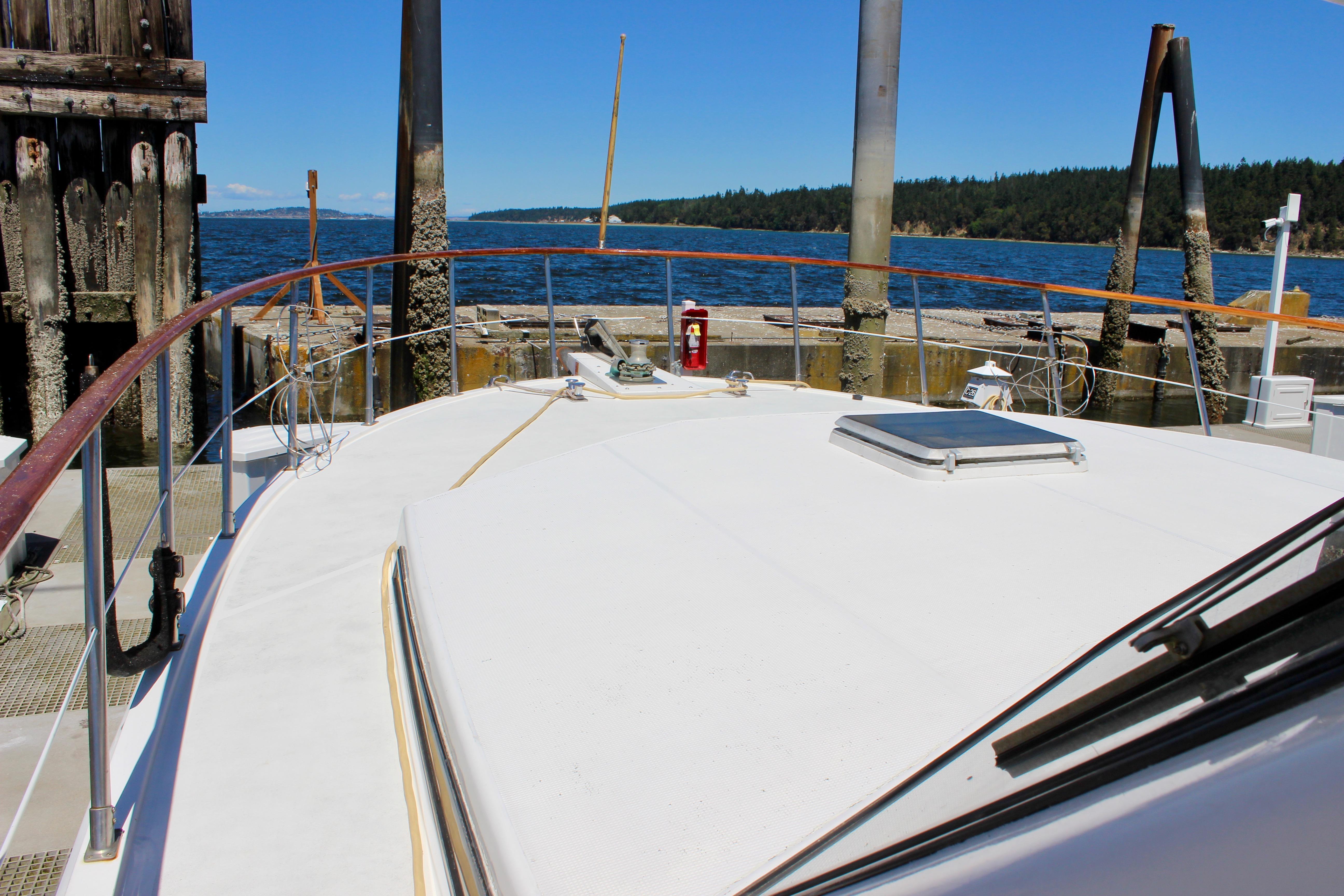 1986 Kha Shing Spindrift 46 yacht docked by a scenic waterfront.
