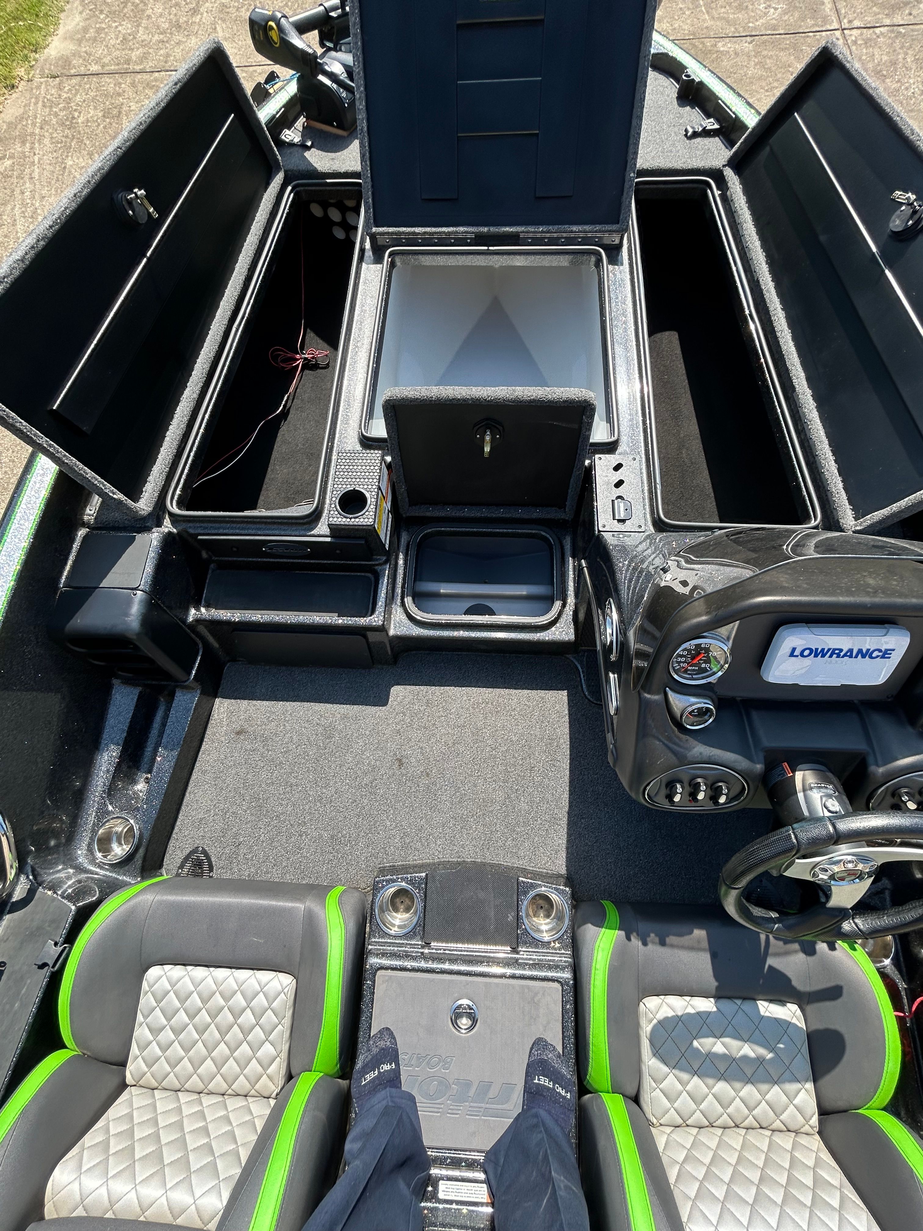 The image shows the cockpit of a Trident 189 TRX boat with open storage compartments.