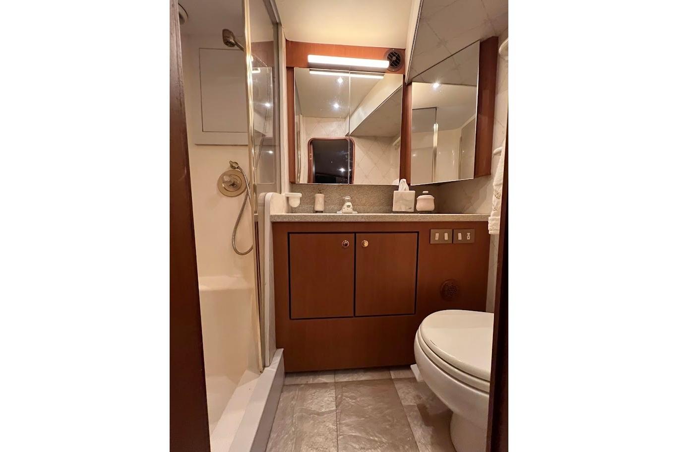 Luxurious bathroom in 2002 Ocean Yachts 56 Super Sport, featuring elegant wood cabinetry.