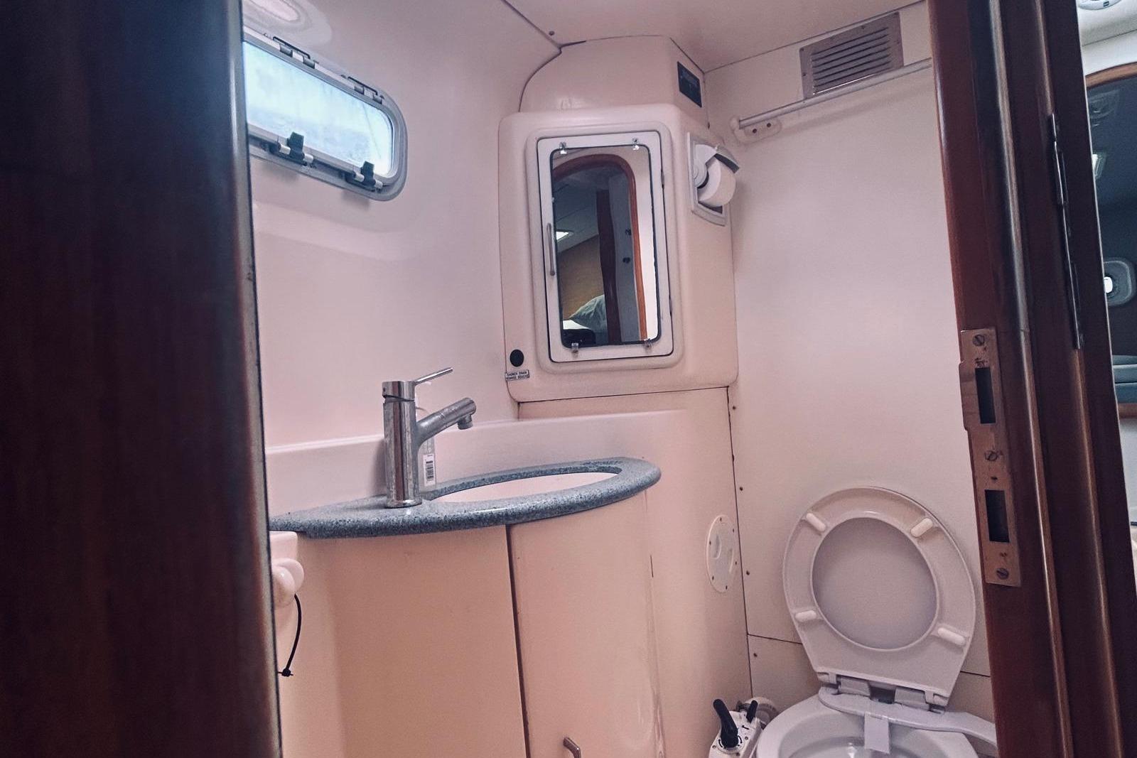 Bathroom interior of a 2001 Robertson & Caine Leopard yacht, featuring sink and toilet.
