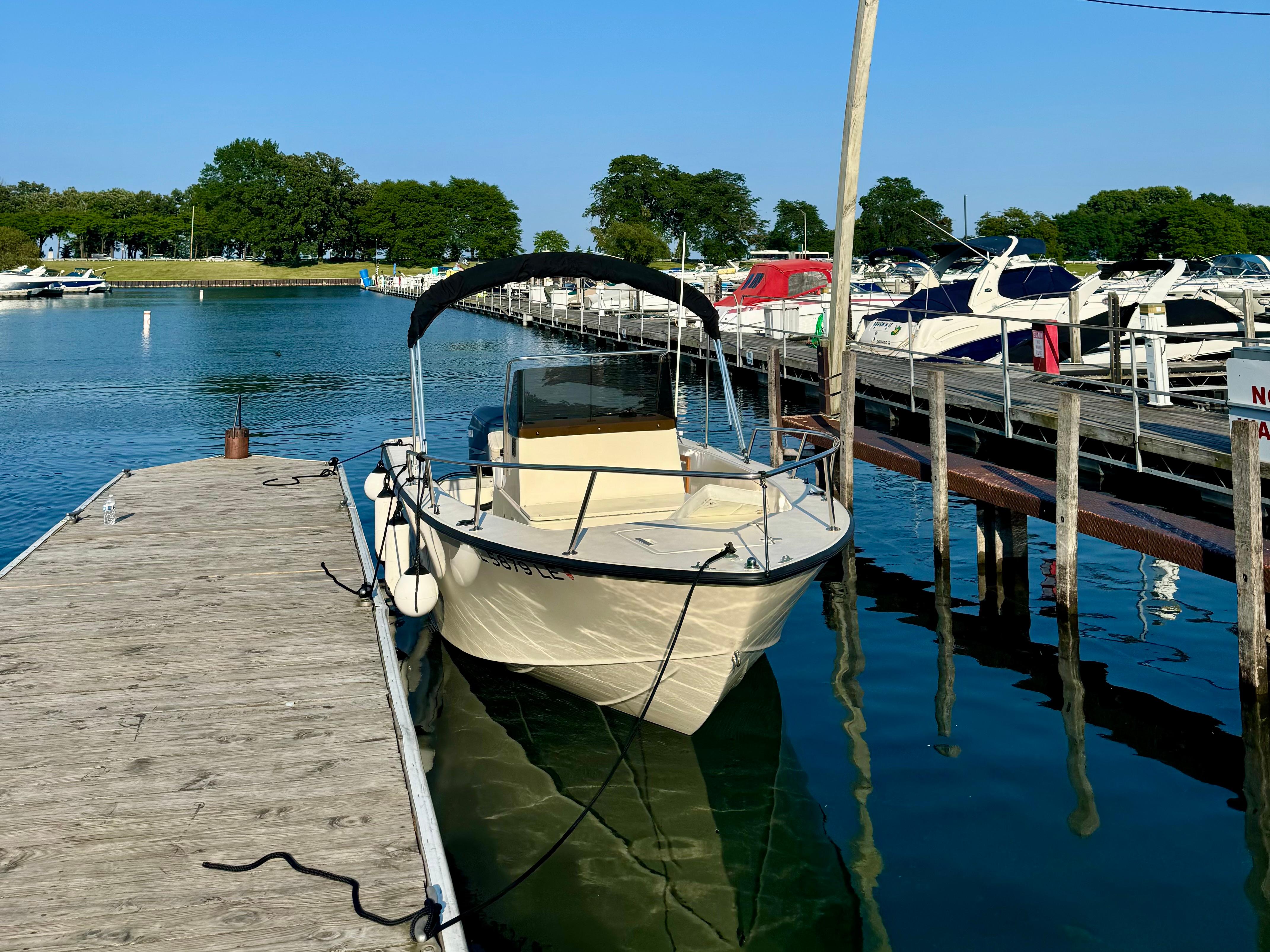 1987 Custom Biddison 2200 boat docked at a marina on a sunny day.