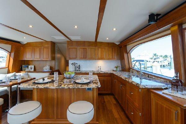 Luxurious interior of 2013 Hatteras GT63 yacht with elegant wooden cabinetry and granite countertops.