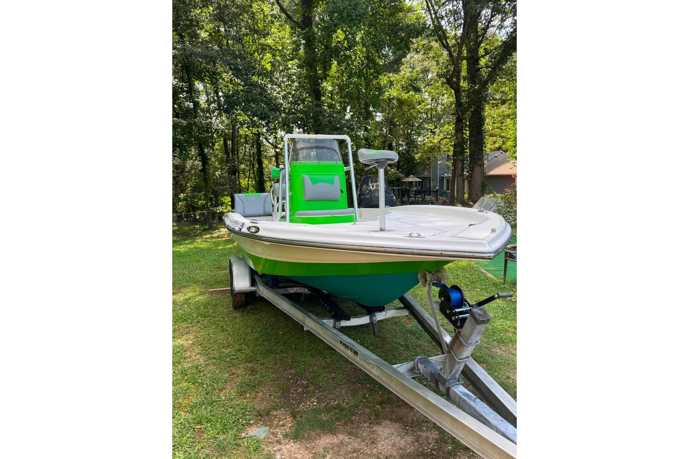 2016 Epic 21 Sport Console boat on trailer, parked on grass with trees in background.