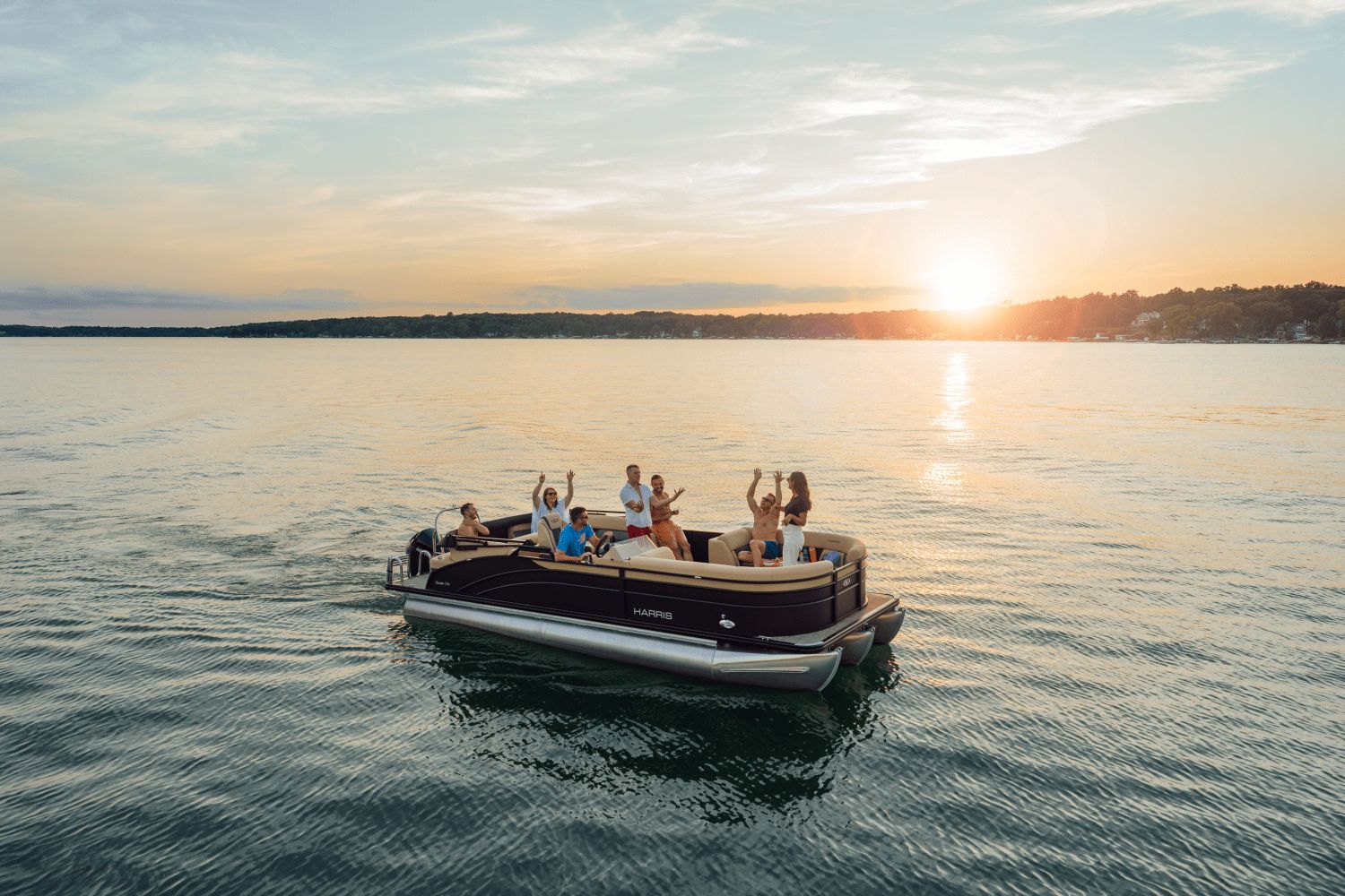 A group of people enjoying a boat ride at sunset on a calm lake.