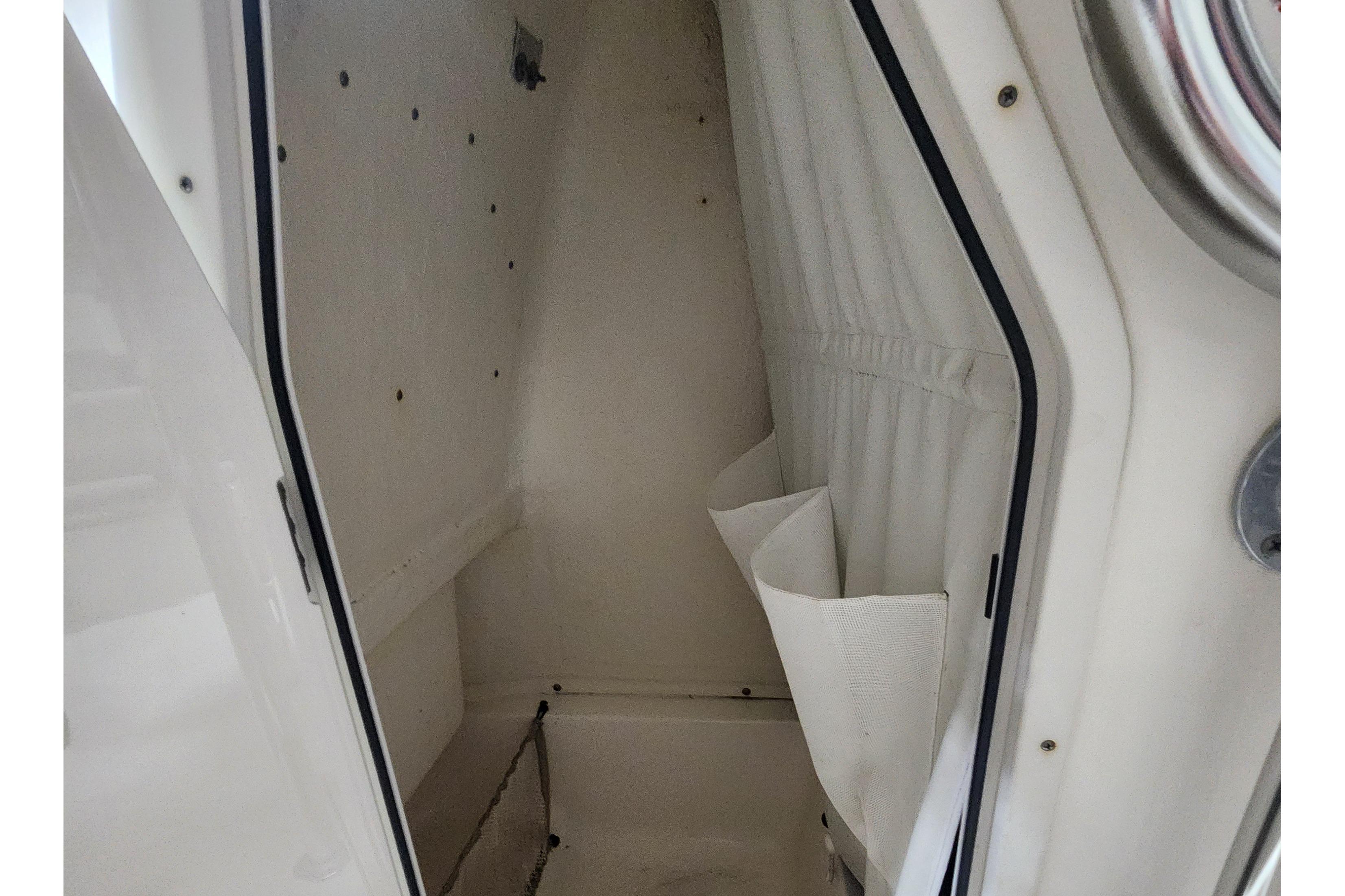 Interior storage compartment of 2023 Key West 219 FS boat, featuring white walls and storage pockets.