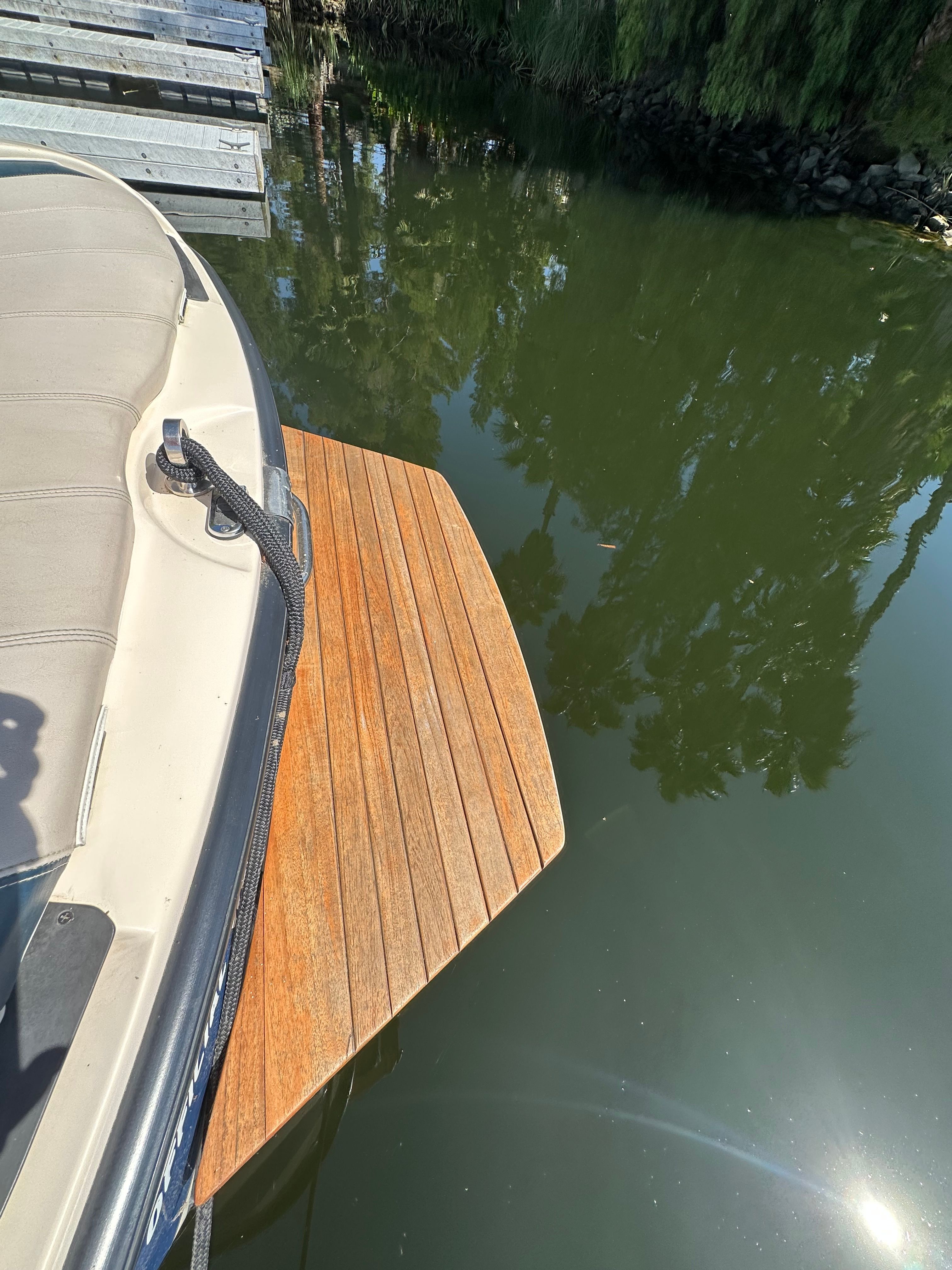 1998 Correct Craft Air Nautique on water with wooden platform.
